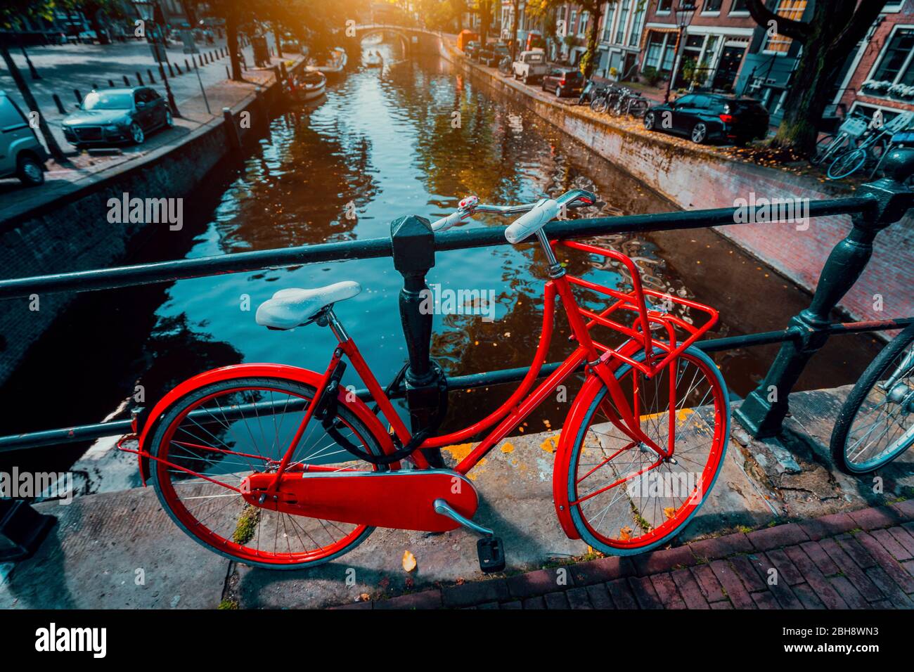 Symboles d'Amsterdam : Vélo rouge garée sur un pont, aux Pays-Bas. Romance, voyage, vacances. Concept de culture Banque D'Images