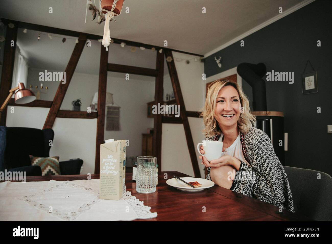 Frau am Frühstückstisch, fröhlich, Kaffee trinken Banque D'Images