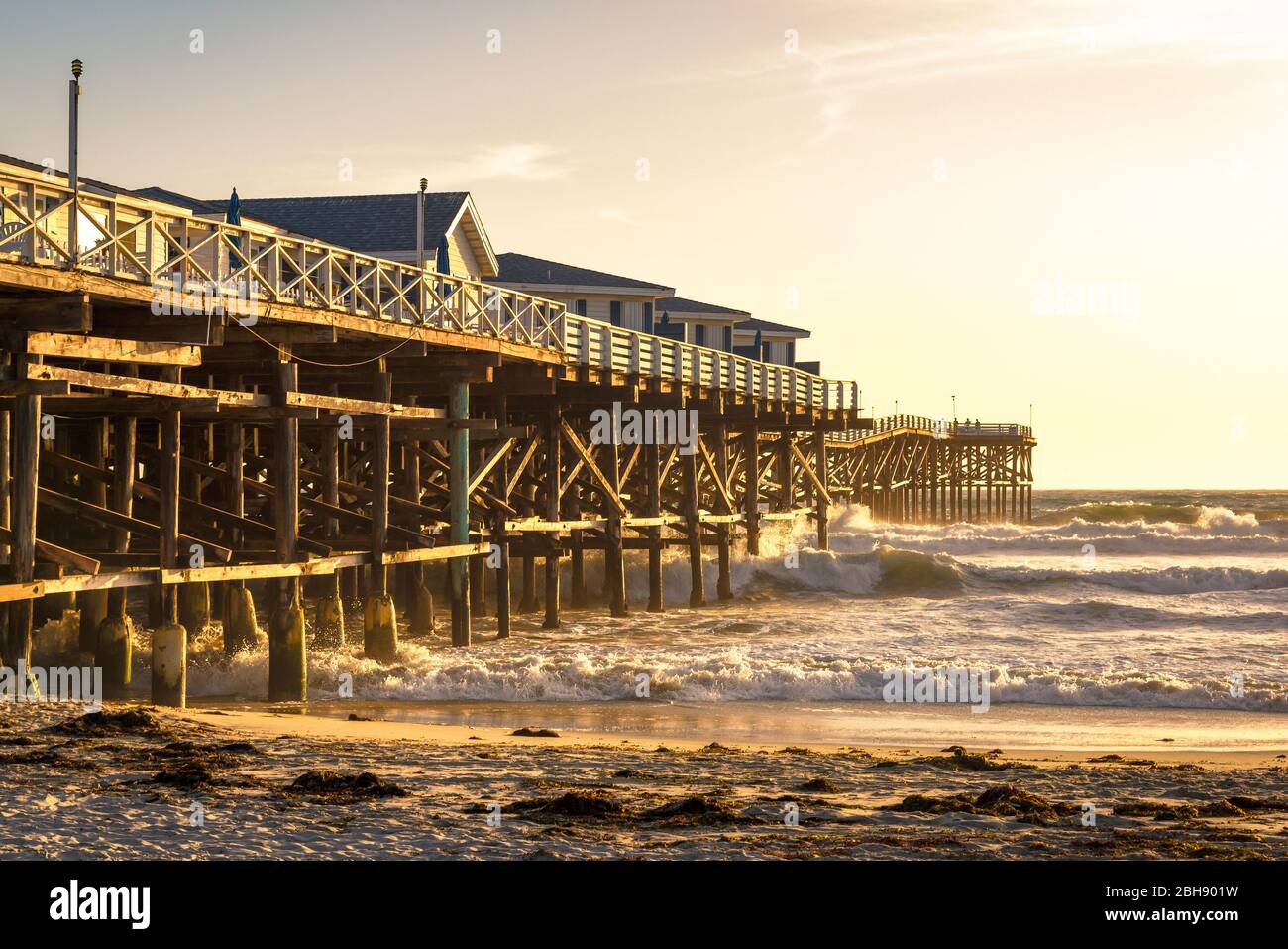 Seitenansicht vom historischen Hölzernem Crystal Pier à San Diego bei Sonnenuntergang, stürmischer Pazifischer Ozean Banque D'Images