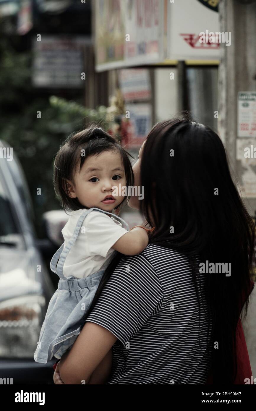 Jeune fille thaïlandaise avec une fille dans ses bras dans la ville Banque D'Images