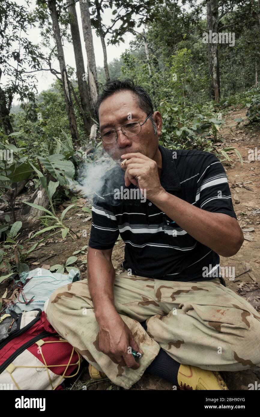 L'homme thaïlandais fume la cigarette thaïlandaise maison dans la jungle Banque D'Images