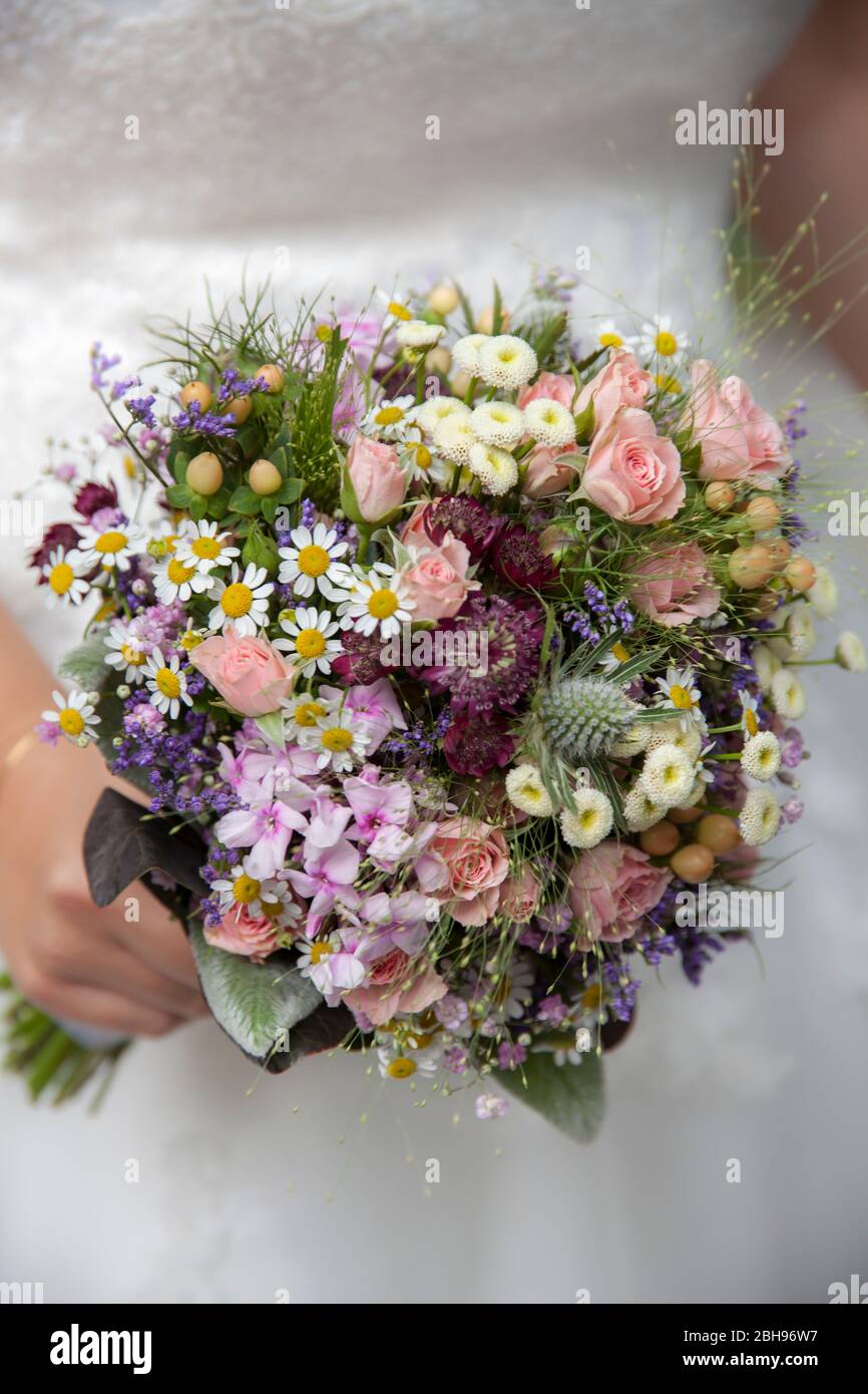 La mariée tient le bouquet de mariée rose dans les mains Banque D'Images