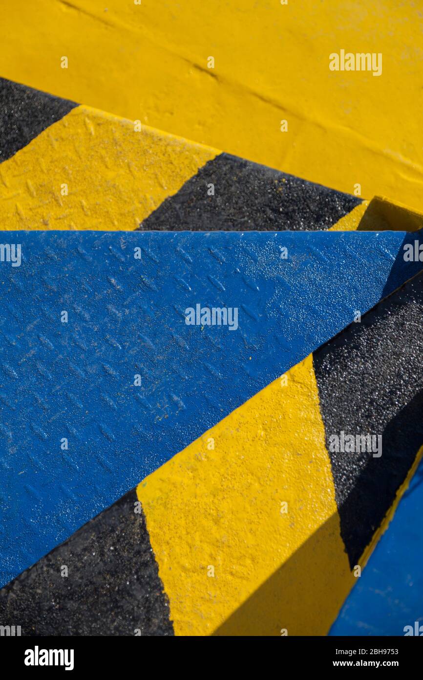 marches métalliques aux couleurs vives sur un ferry, couleur jaune bleu contrasté noir, vue sur les escaliers Banque D'Images