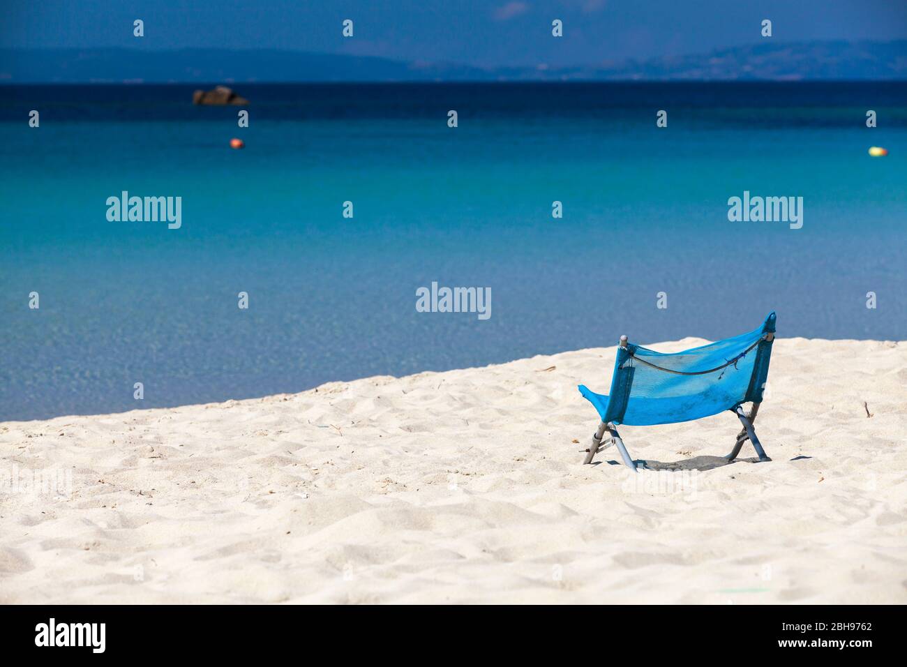 Chaise de plage bleue dans le sable blanc contre une mer bleue, vue sur l'immensité, Amouliani, Ammouliani, Golfe Singitique, nord de la mer Égée, Halkidiki, Grèce Banque D'Images