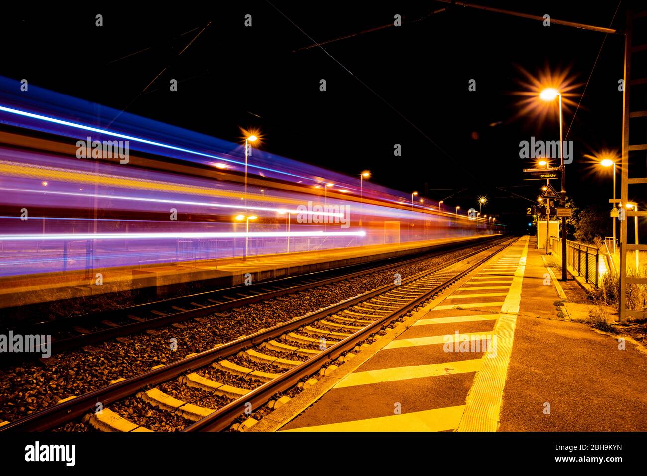 Longue exposition de trains en train dans la nuit dans une gare Banque D'Images