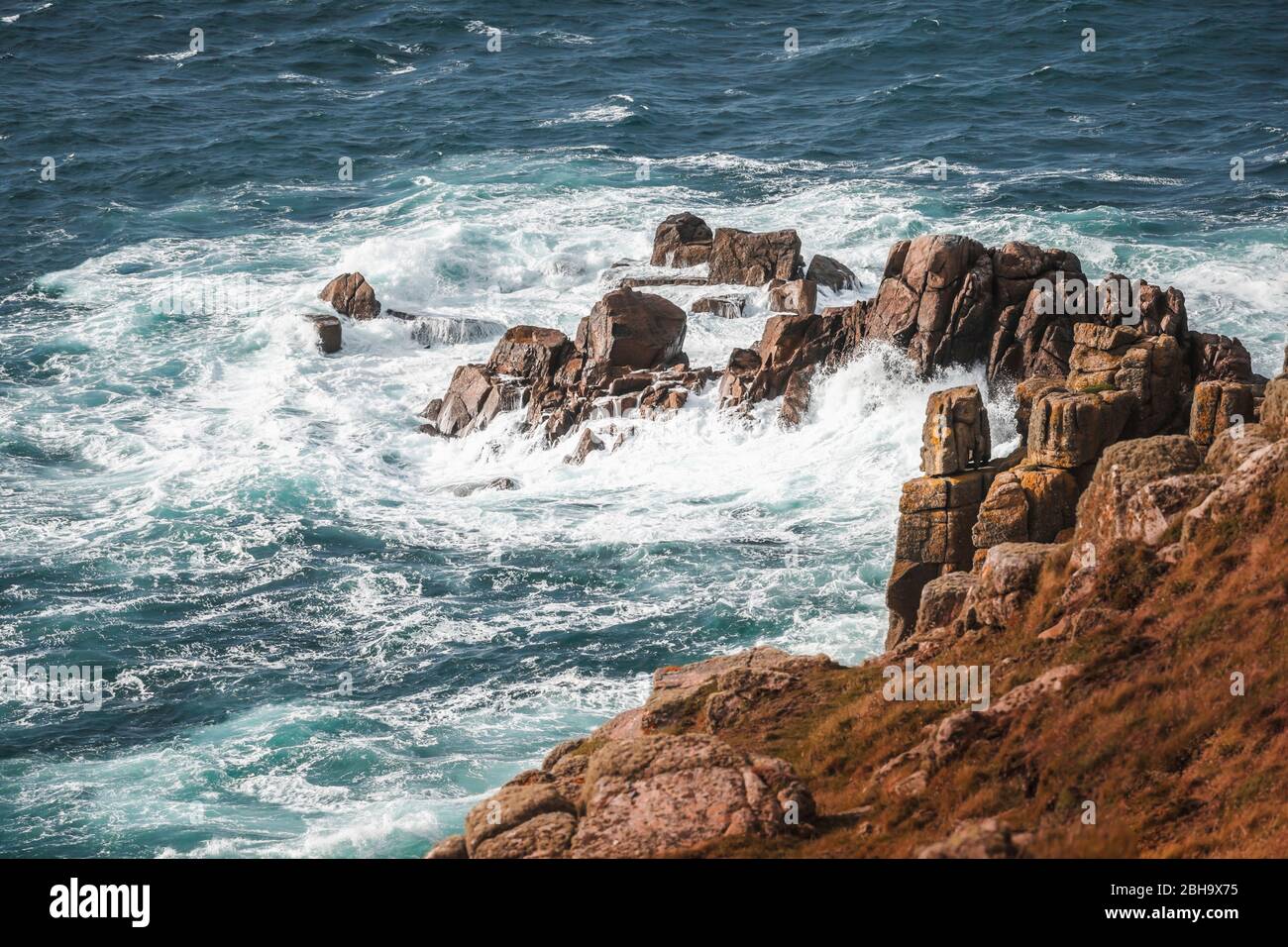 Vagues et gerbe sur le rocher, sur la côte à Lands End, Penzance, Cornwall, Angleterre, Royaume-Uni Banque D'Images