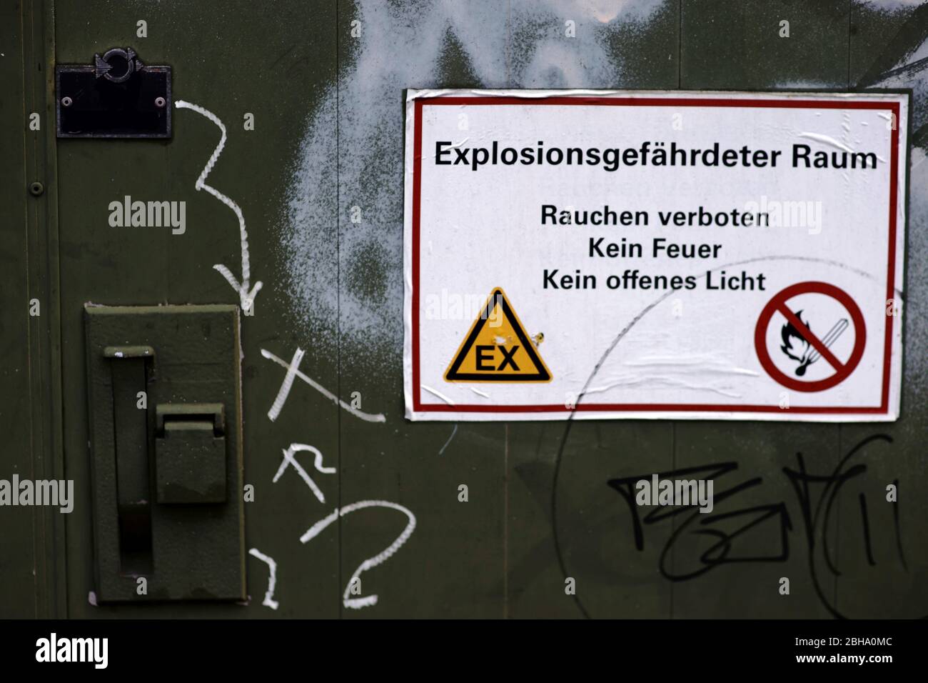 Un réservoir de produits chimiques avec porte verrouillable et sécurisé ainsi qu'une étiquette d'avertissement : Attention : zone explosive. Banque D'Images