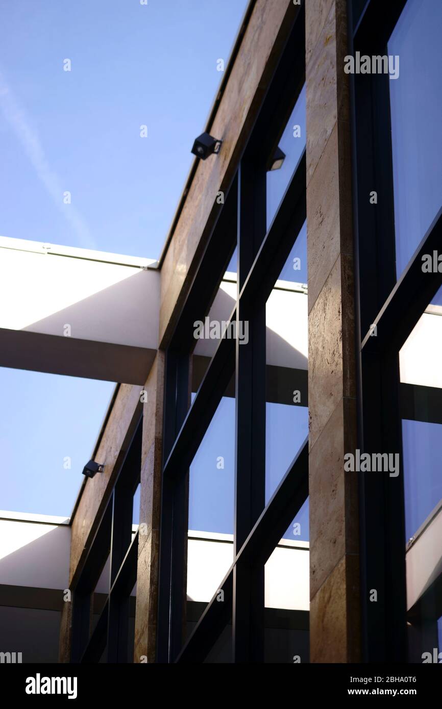 La façade moderne en verre d'un immeuble moderne avec une construction en acier et les bords de toit ouvert. Banque D'Images