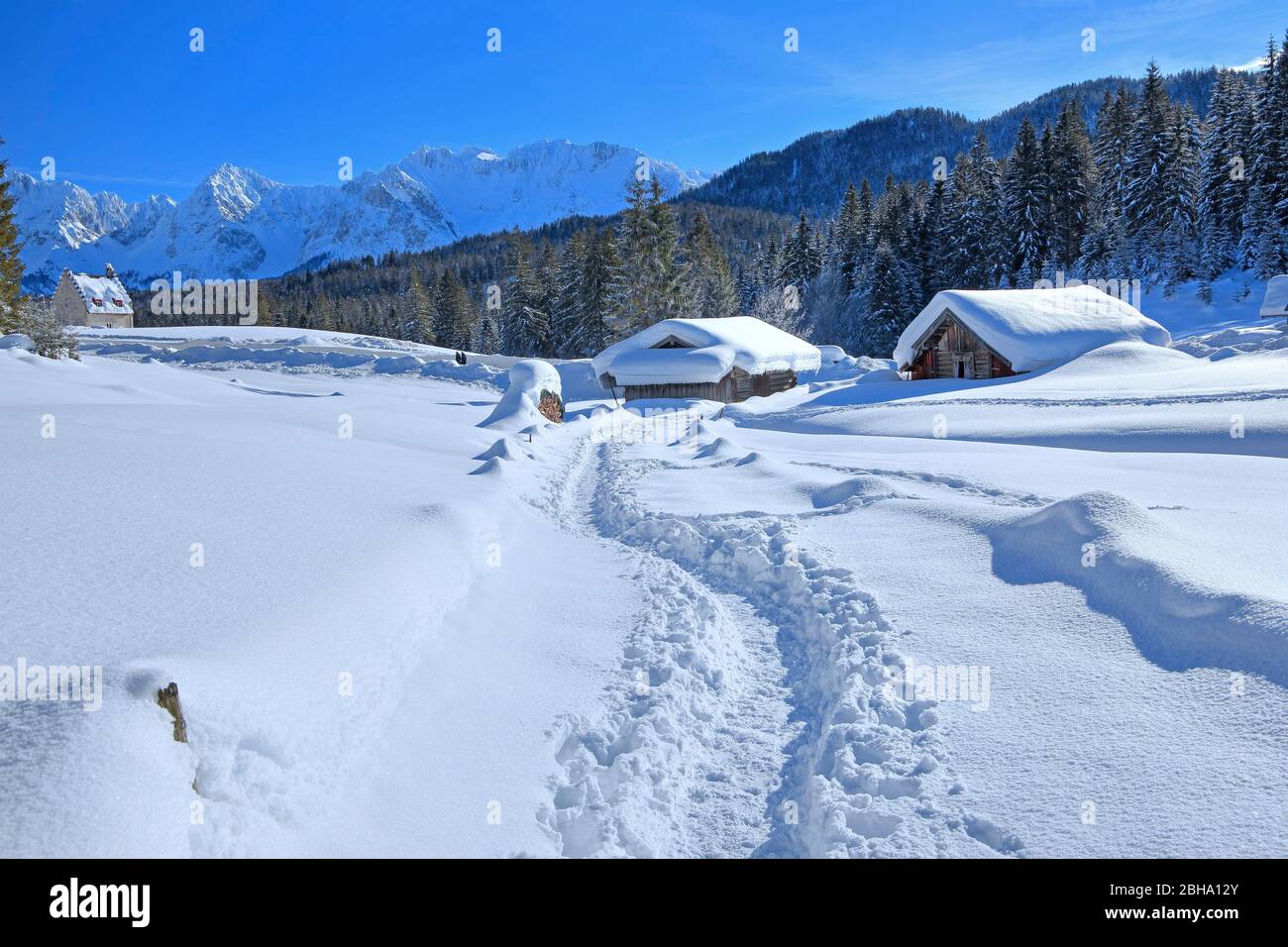 Cabanes enneigées de Winterly avec les montagnes de Karwendel dans l'Elmau, à Klais, Mittenwald, Haute-Bavière, Bavière, Allemagne Banque D'Images
