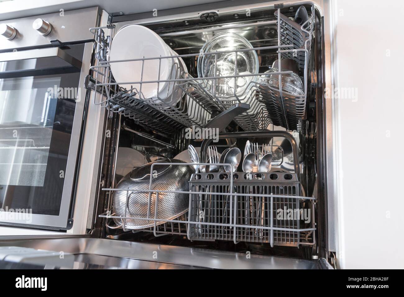 Ouvrez le lave-vaisselle avec des plats propres dans une cuisine blanche Banque D'Images