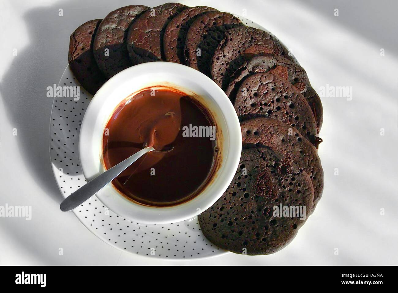 Biscuits au chocolat faits à la main avec mousse au chocolat sur un plat rond sur une nappe légère. Banque D'Images