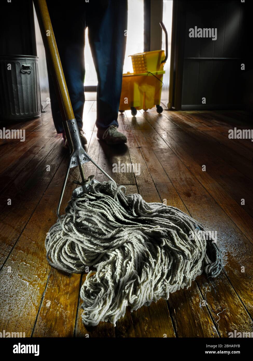 Détail de la mop humide pendant que le concierge mlave le plancher en bois Banque D'Images