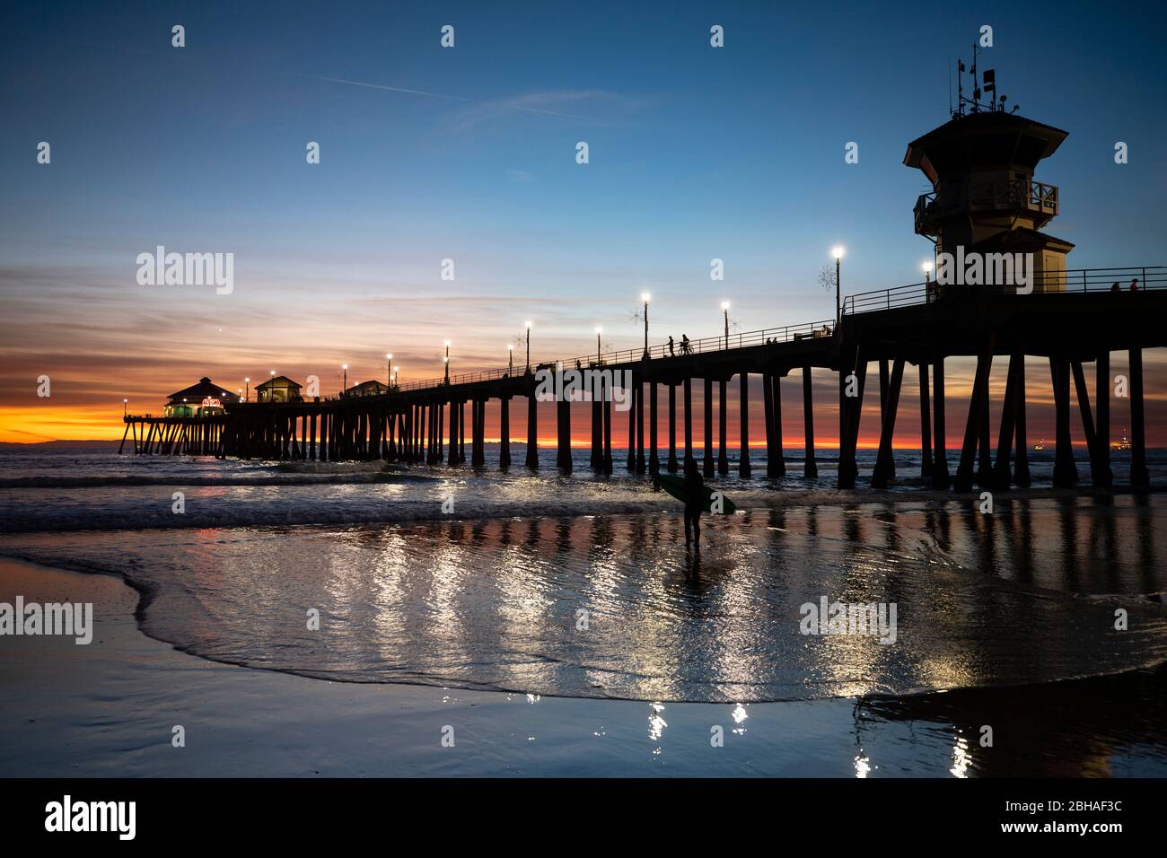 Silhouette de surfeur à Huntington Beach Pier au coucher du soleil, Californie, États-Unis Banque D'Images
