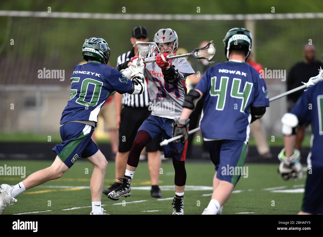 Deux défenseurs ferment sur un adversaire lorsqu'il a essayé de sortir d'un tir sur le but pendant un match de crosse de lycée. ÉTATS-UNIS. Banque D'Images