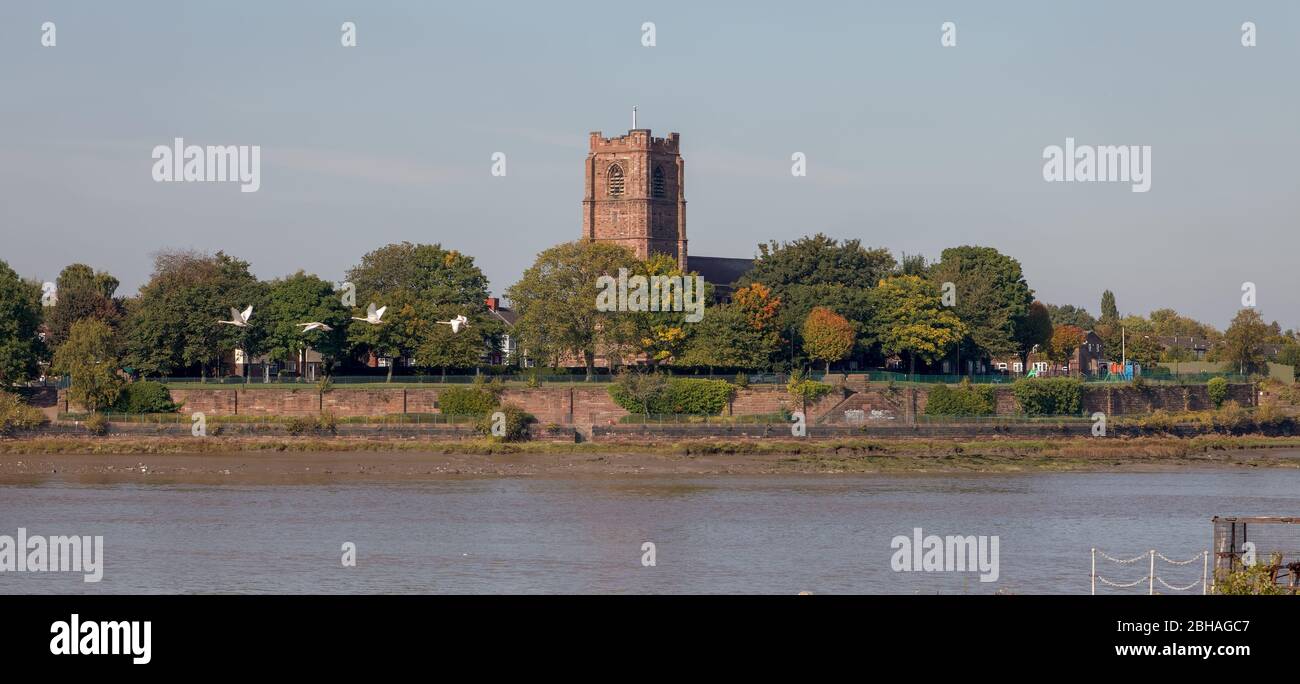 Église St Mary's et vol de cygnes à Widnes, vu de l'autre côté de l'estuaire de Mersey depuis le ferry Mersey lors d'une croisière le long du canal des navires de Manchester Banque D'Images