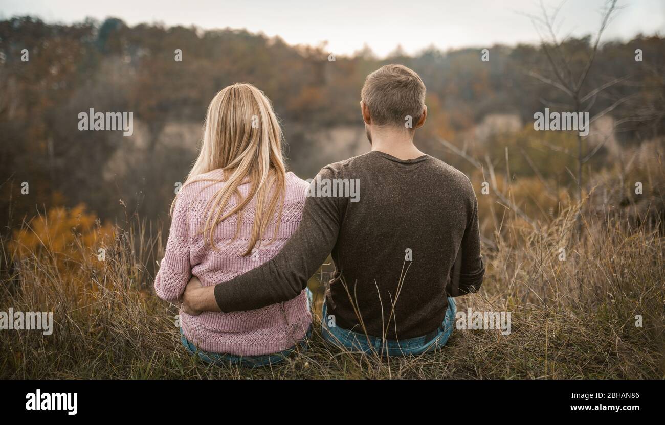 Couple en amour assis dans la nature, vue de l'arrière Banque D'Images