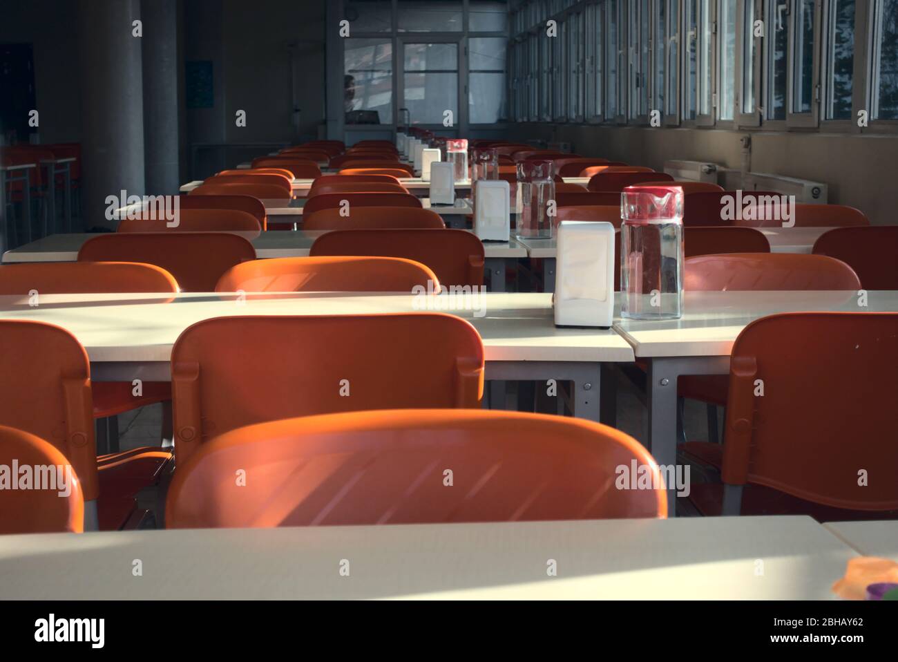 Gros plan de sièges rouges vides d'une cafétéria universitaire après la fermeture des écoles Banque D'Images
