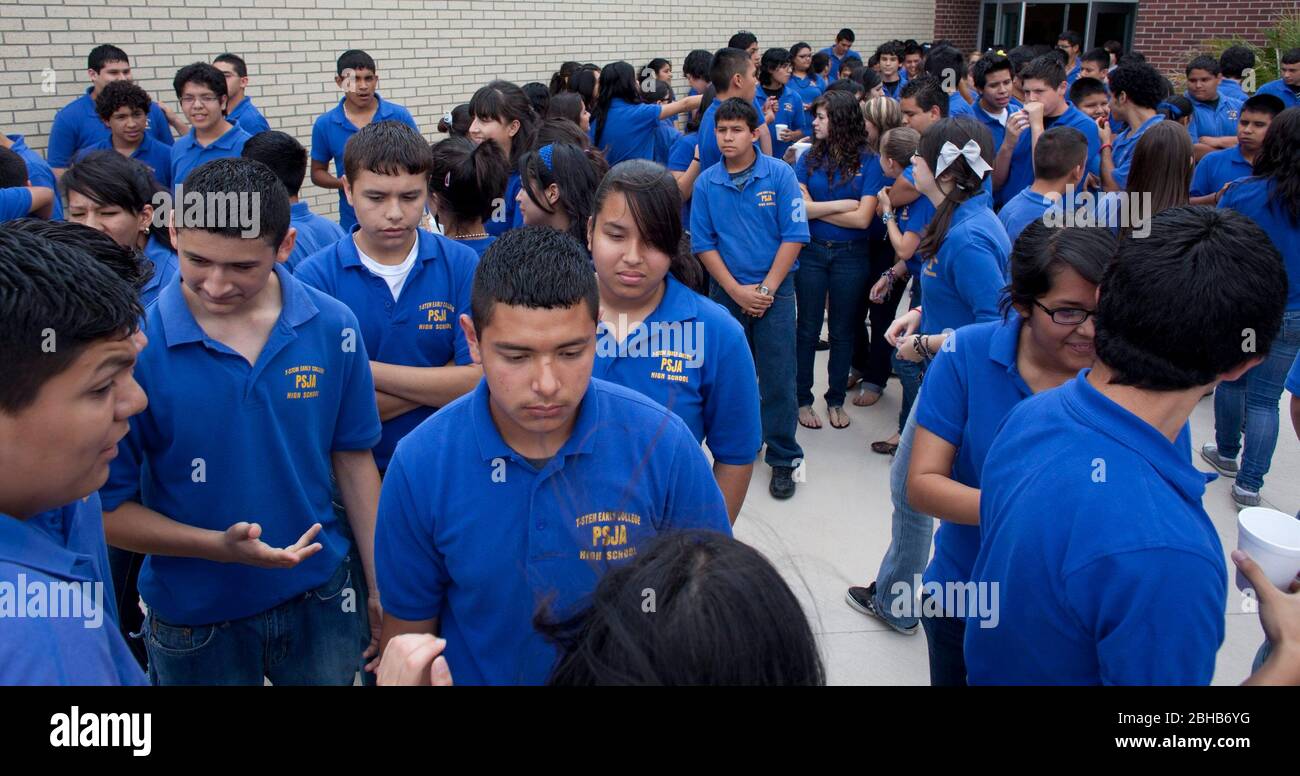 Pharr Texas USA, 13 mai 2010: Les élèves du lycée de la première école secondaire du district scolaire Pharr-San Juan-Alamo se mêlent à l'extérieur tout en attendant leurs bus scolaires sur le campus de l'extrême sud du Texas. Les élèves doivent porter les chemises bleues uniformes pendant la journée d'école. L'école donne aux étudiants la possibilité de gagner du crédit d'université tout en prenant des cours de lycée avancés et d'obtenir un départ de tête sur l'université. ©Bob Daemmrich Banque D'Images