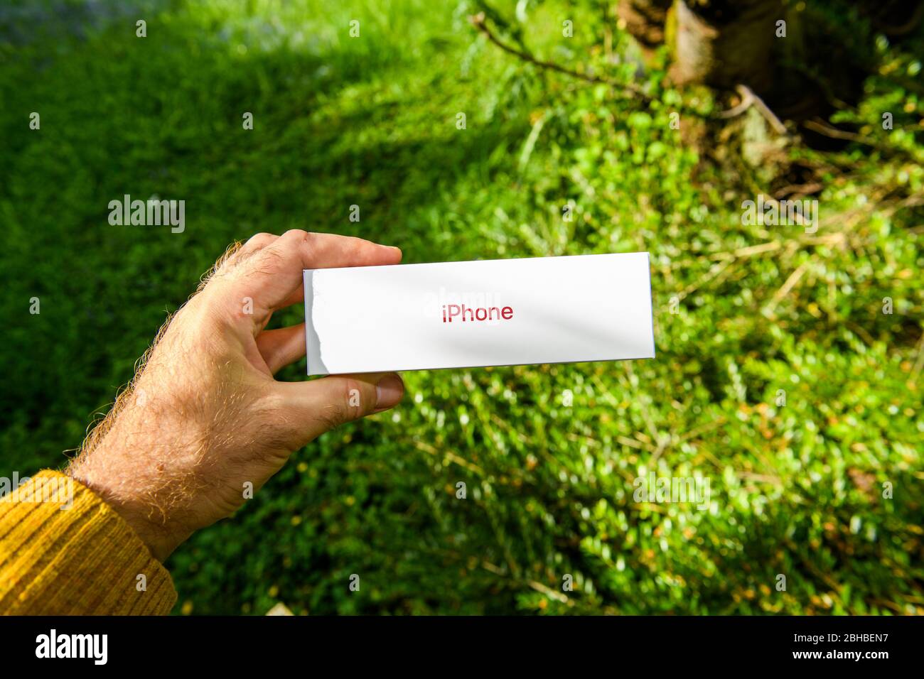 Paris, France - 24 avril 2020: Homme présentant dans jardin nouveau budget iPhone se par Apple Computers touch ID, caméra arrière à objectif unique et iPhone 8 design avec interne à partir de la version 11 Pro Banque D'Images