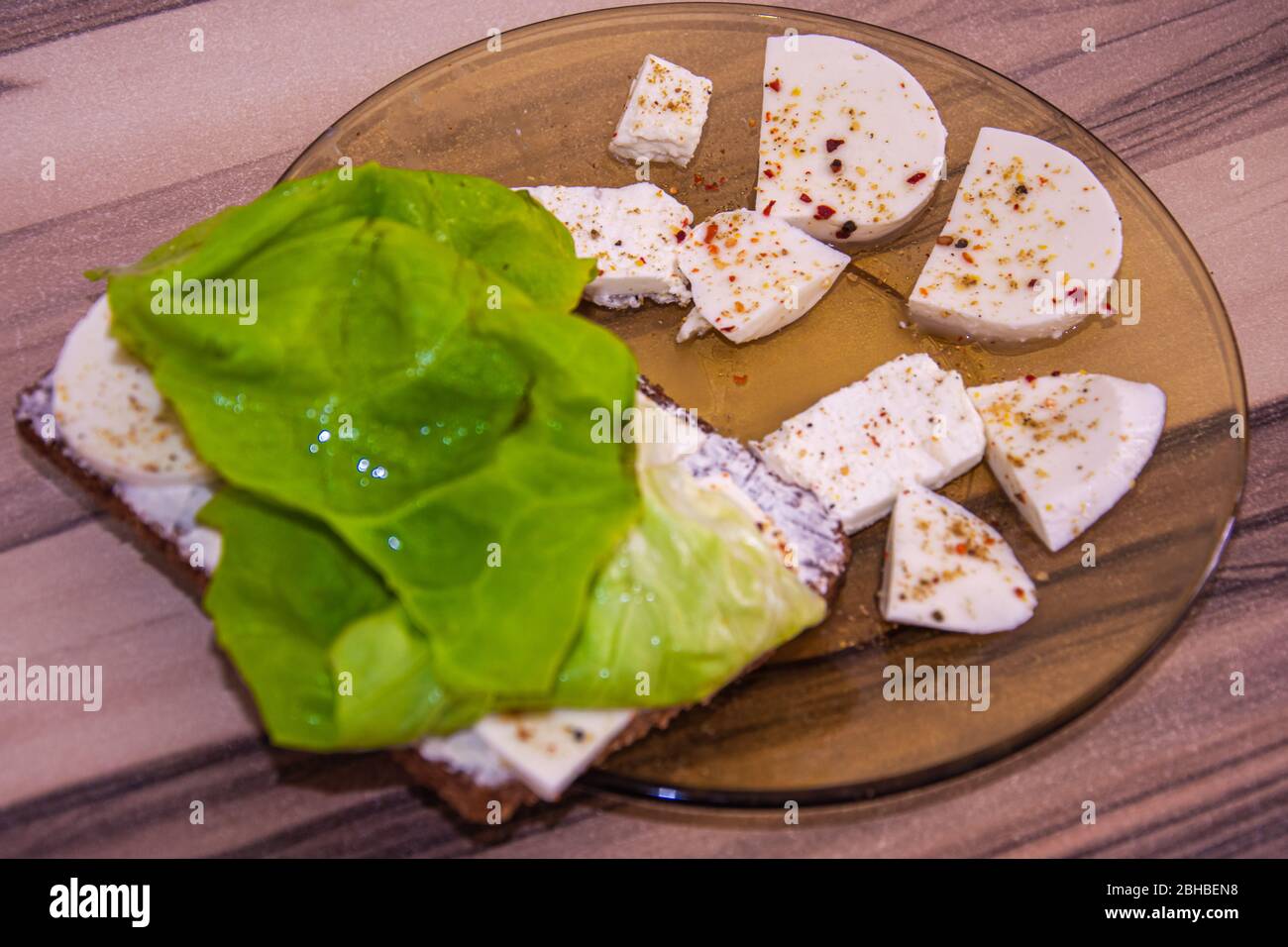 Plaque de verre avec fromage blanc aromatisé et laitue verte Banque D'Images
