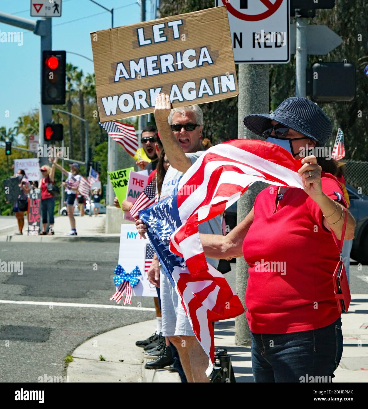 OpenUpCA, Newport Beach, Californie, 24 avril 2020, les manifestants se rallient autour de la périphérie de Newport Beach , agitant des drapeaux américains exigeant la réouverture de la Californie. Banque D'Images