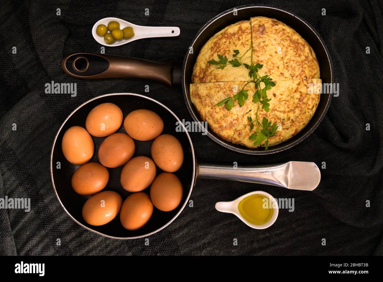 Une vue rapprochée à angle élevé de deux torréfacteurs dans des directions opposées avec des œufs frais et une omelette avec jaune d'œuf et olives sur les côtés Banque D'Images