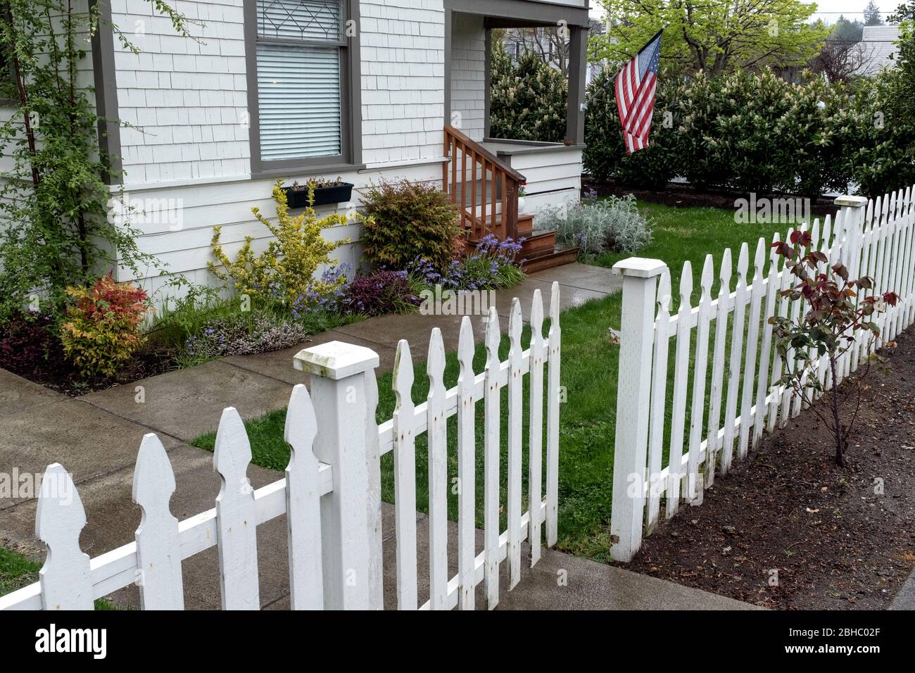WA17462-00-BW .... WASHINGTON - Maison avec clôture de piquetage et drapeau américain. Banque D'Images