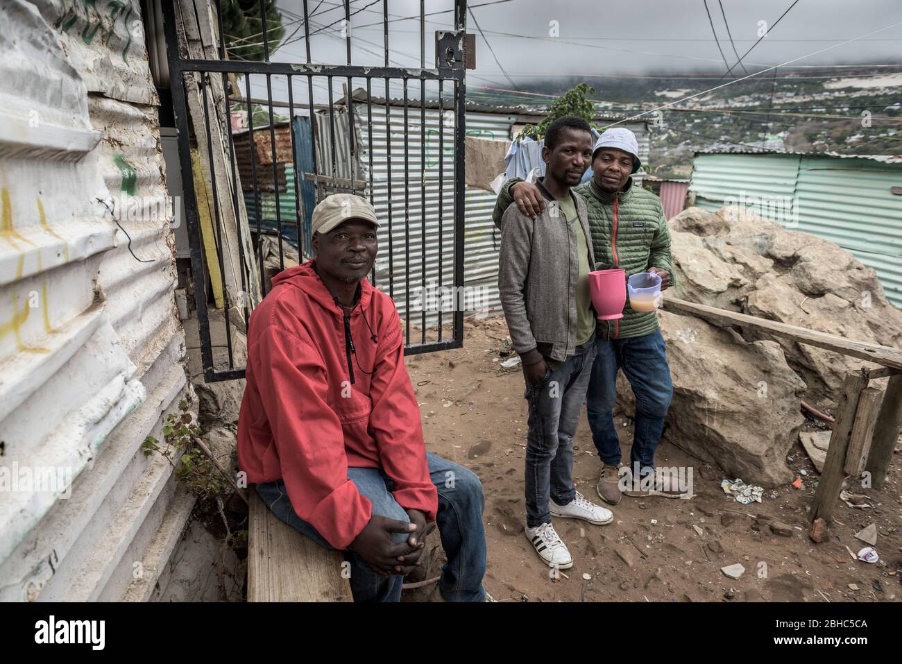 Les habitants du canton d'Imizamo Yethu de Hout Bay boivent de la bière traditionnelle pendant le verrouillage du coronavirus en Afrique du Sud qui interdit la consommation d'alcool Banque D'Images