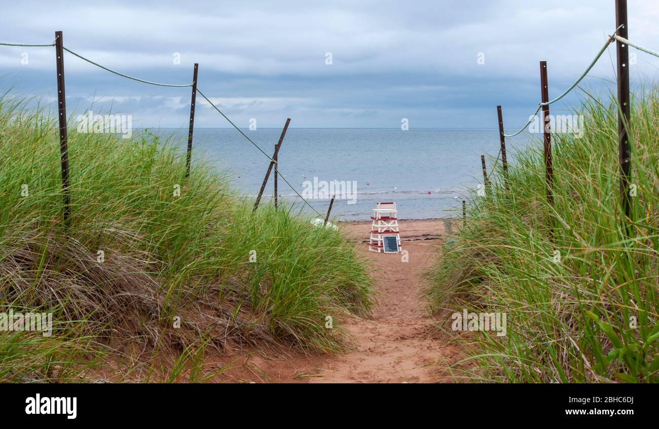 Chemin clôturé à travers les dunes de sable. Chaise de maître-nageur sur une plage déserte en bord de mer. North Rustico Beach, parc national de l'Île-du-Prince-Édouard, Canada Banque D'Images