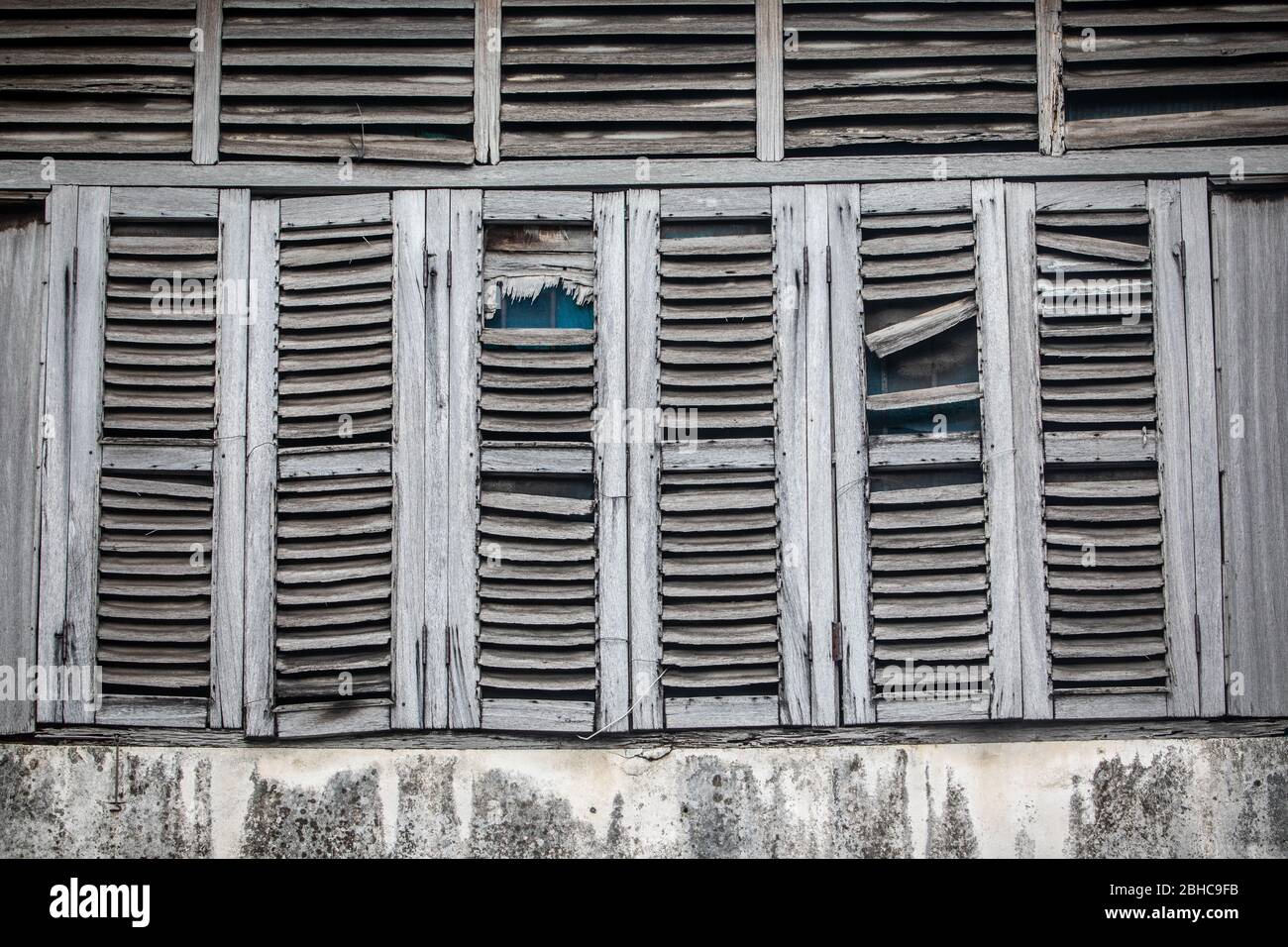 Fenêtres anciennes, usées par le temps. Volets en bois gris. Maison abandonnée. Banque D'Images