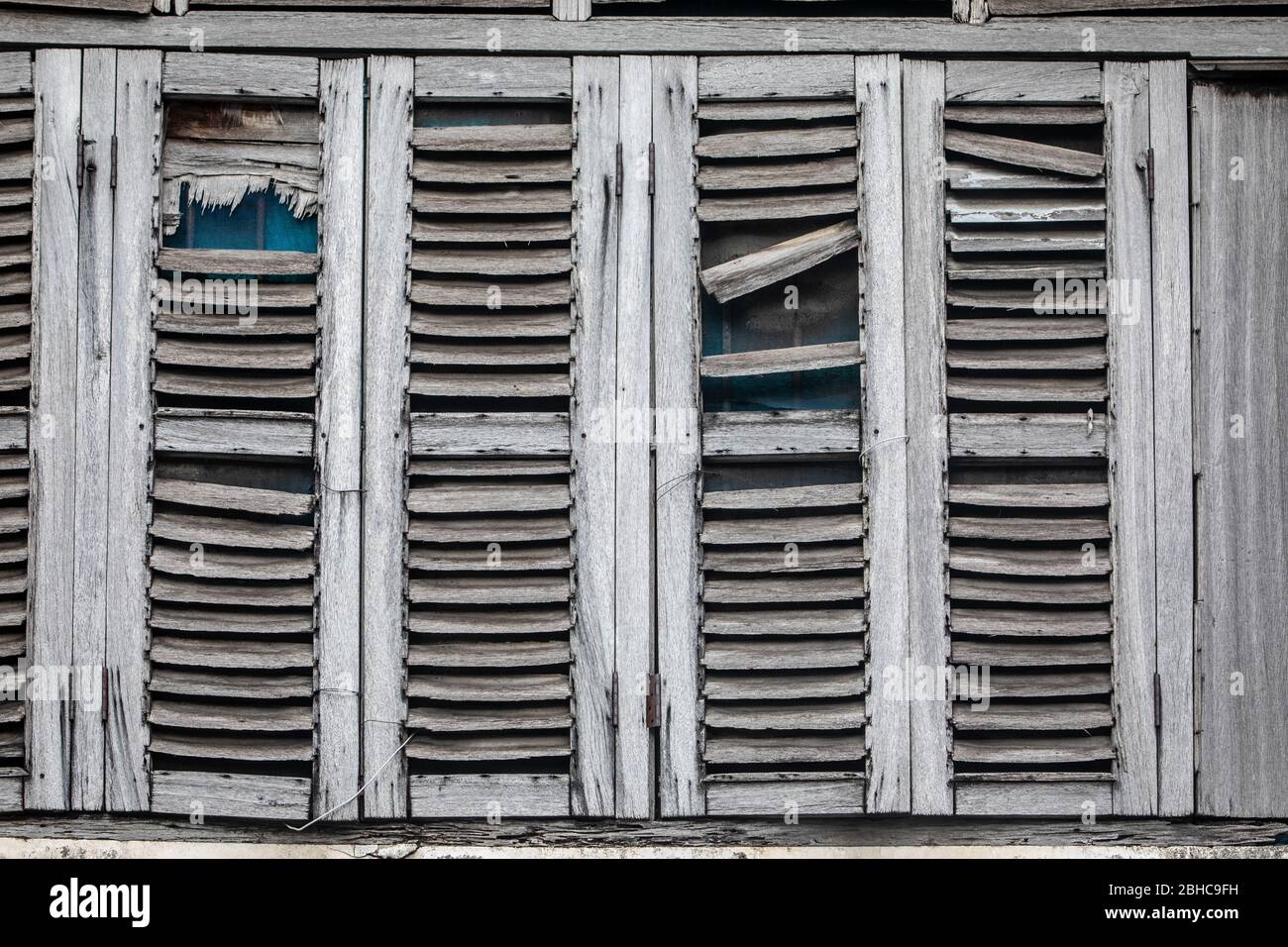 Fenêtres anciennes, usées par le temps. Volets en bois gris. Maison abandonnée. Banque D'Images
