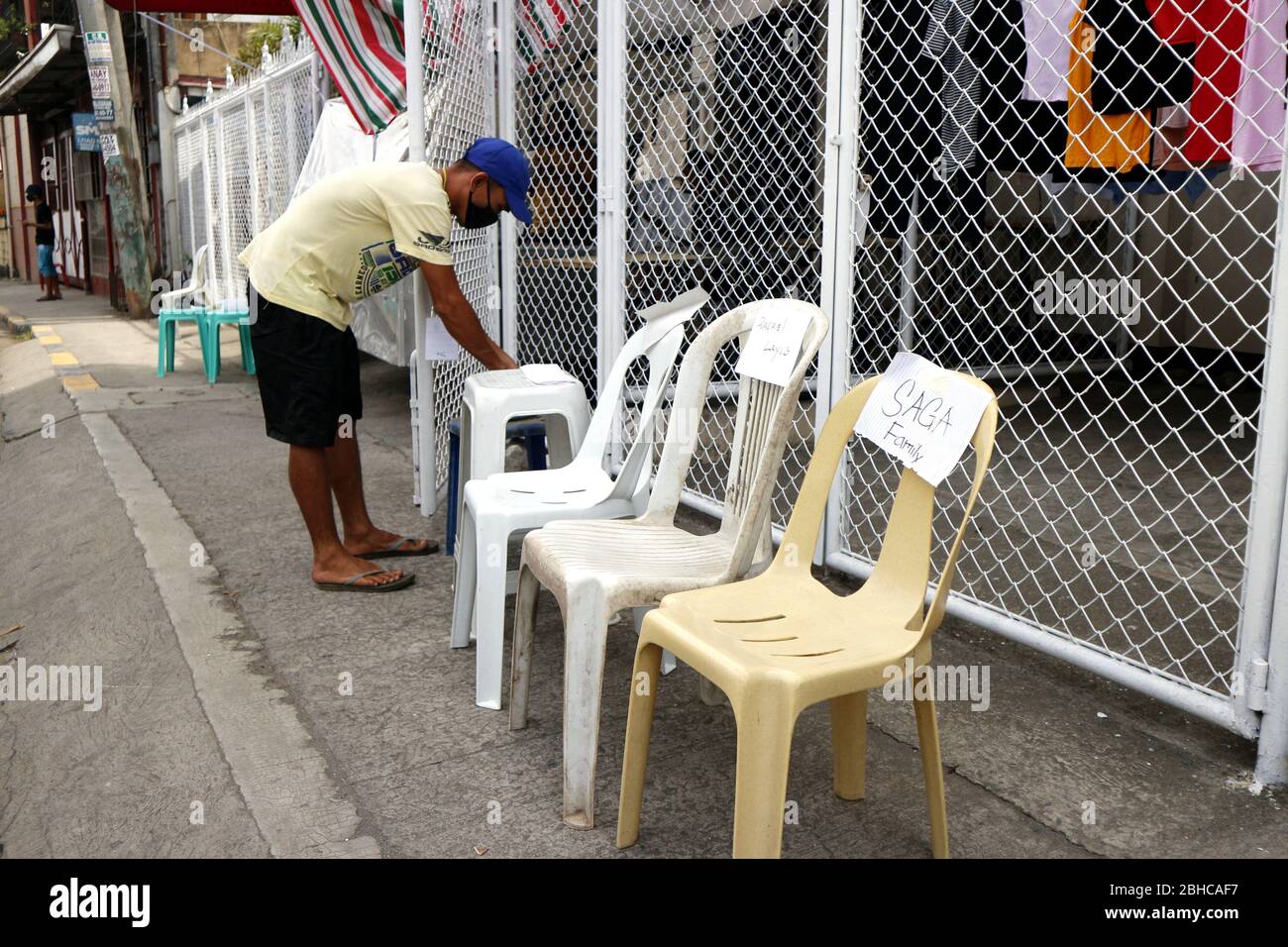 Antipolo City, Philippines - 23 avril 2020: Les résidents mettent des chaises devant leurs maisons pour que les travailleurs du gouvernement puissent mettre des produits de secours sans contact t Banque D'Images