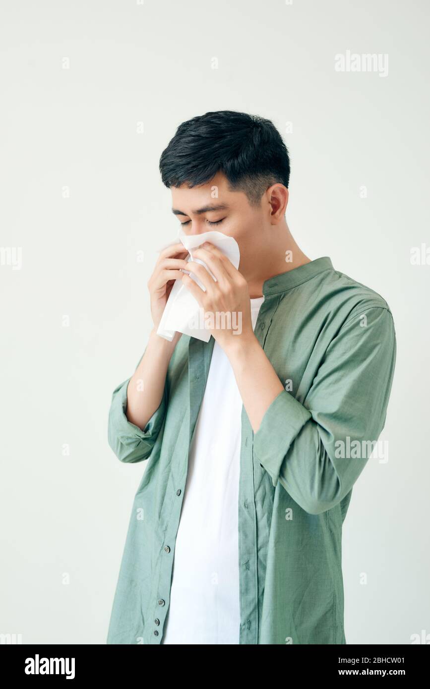 Les jeunes asiatiques éternuent après avoir reçu le virus de l'allergie ou de la grippe et en utilisant du papier de tissu pour glisser sur le nez à la clinique médicale après avoir obtenu le coronavirus (covid-19) di Banque D'Images
