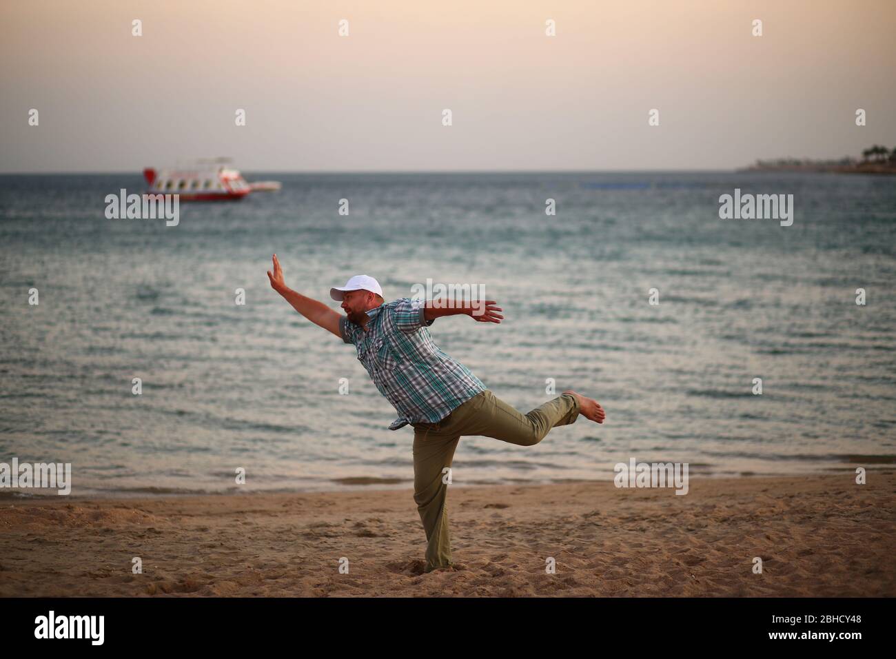 Portrait d'un homme caucasien en course pressé sur une plage de coucher de soleil Banque D'Images