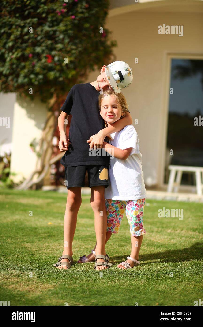 Portrait d'un garçon et d'une fille enhugents sur la pelouse ensoleillée d'été. Amour Banque D'Images