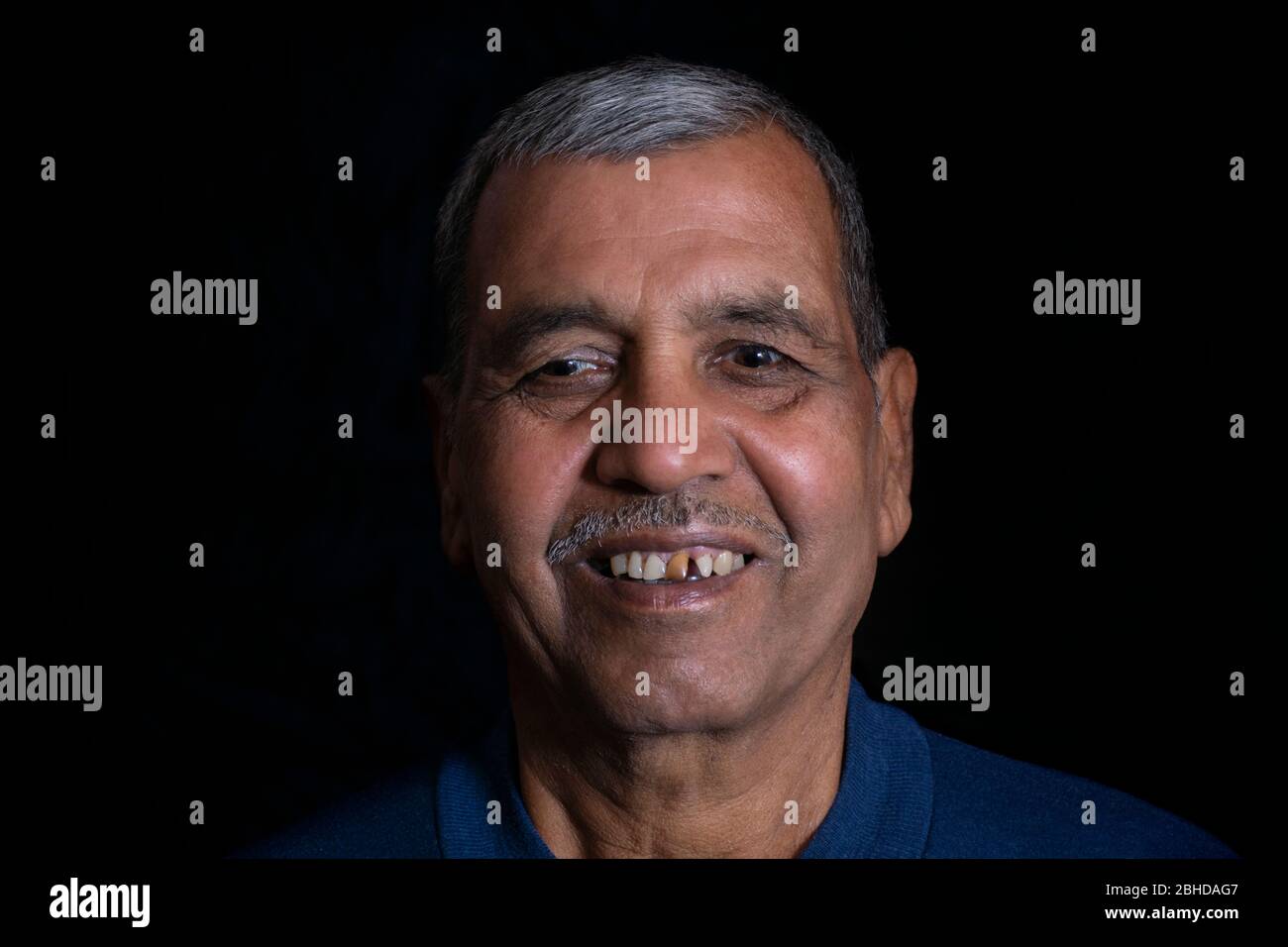 Close-up portrait of happy senior man sur fond noir Banque D'Images