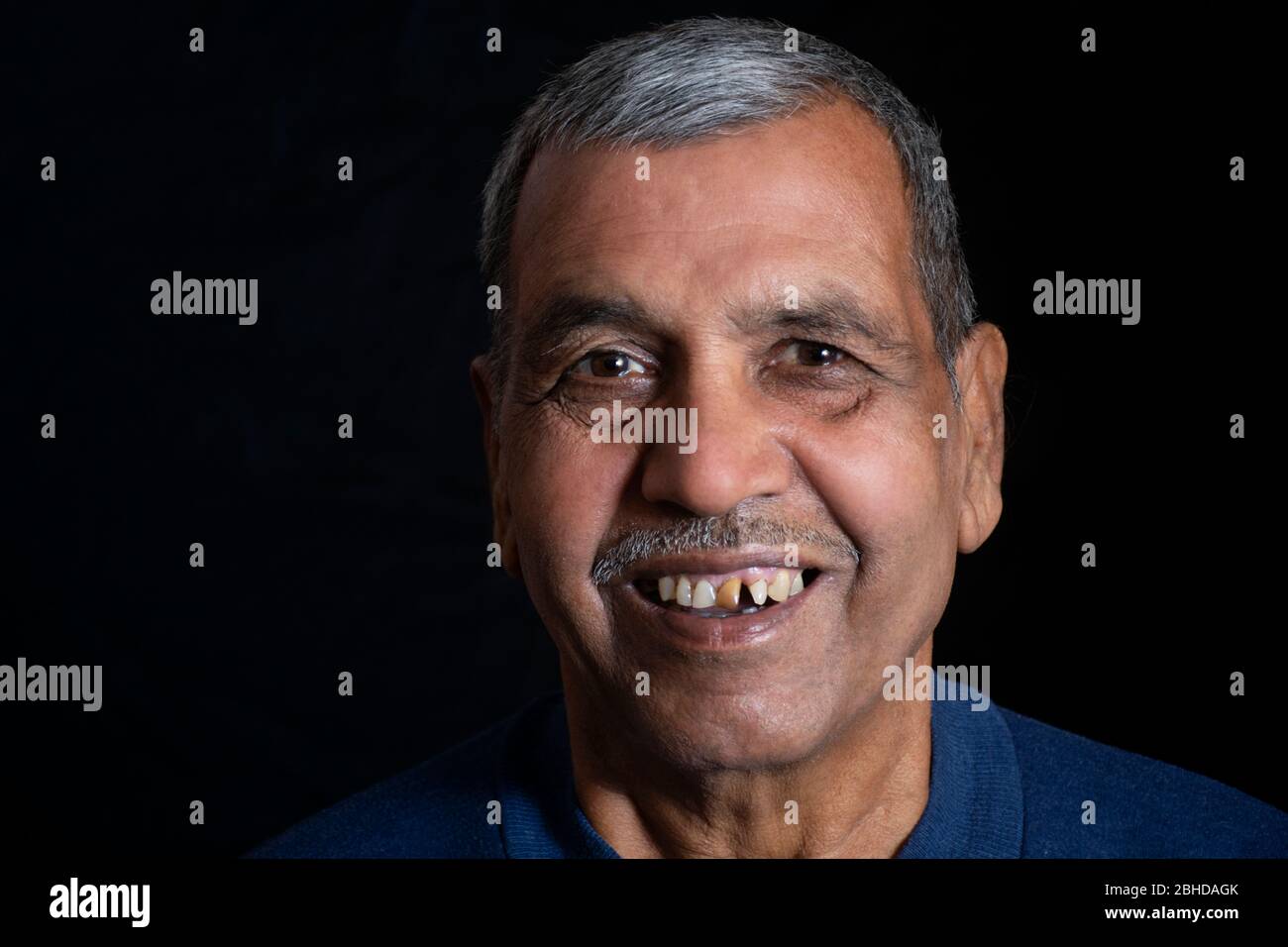 Close-up portrait of happy senior man sur fond noir Banque D'Images