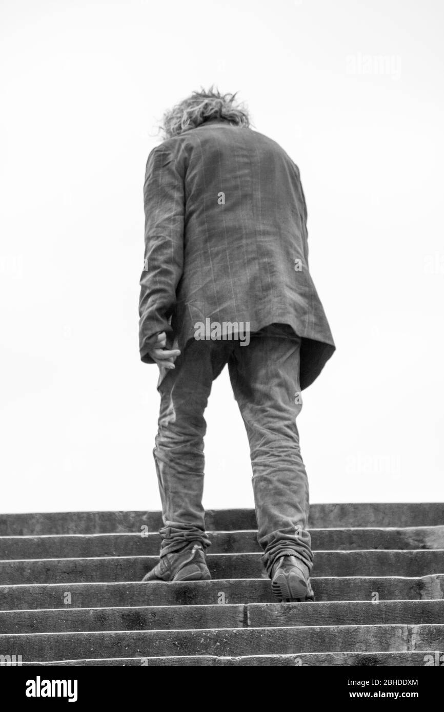 Un homme solitaire monte à pas à Paris, France Banque D'Images
