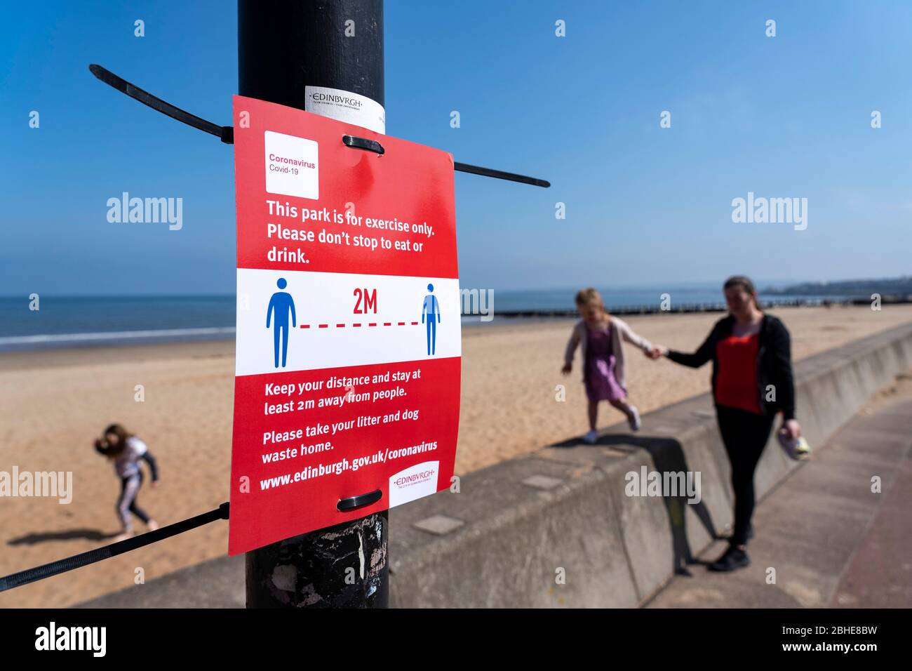 Portobello, Écosse, Royaume-Uni. 25 avril 2020. Vue sur les personnes en plein air le samedi après-midi sur la plage et la promenade de Portobello, à Édimbourg. Le beau temps a amené plus de gens à faire de la marche et du vélo à l'extérieur. La police patrouillait dans les véhicules mais ne s'arrête pas parce que la plupart des gens semblent observer des distances sociales. Signe d'avertissement sur les distances sociales. Iain Masterton/Alay Live News Banque D'Images