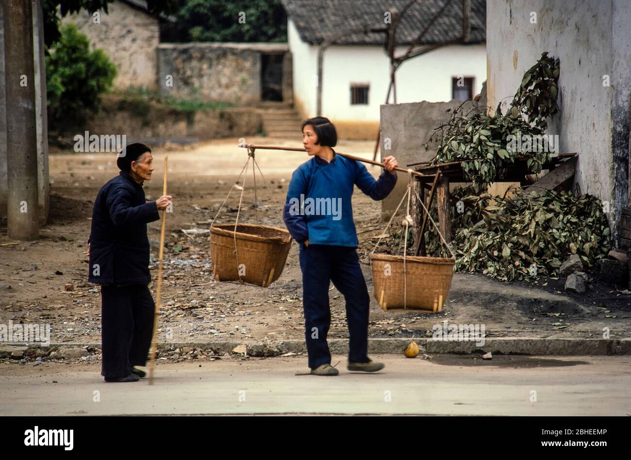 Yangshuo, Chine - 1987 mars : deux personnes ont eu une conversation dans une rue de la ville rurale de Yangshuo, Chine. Film 35 mm numérisé. Banque D'Images