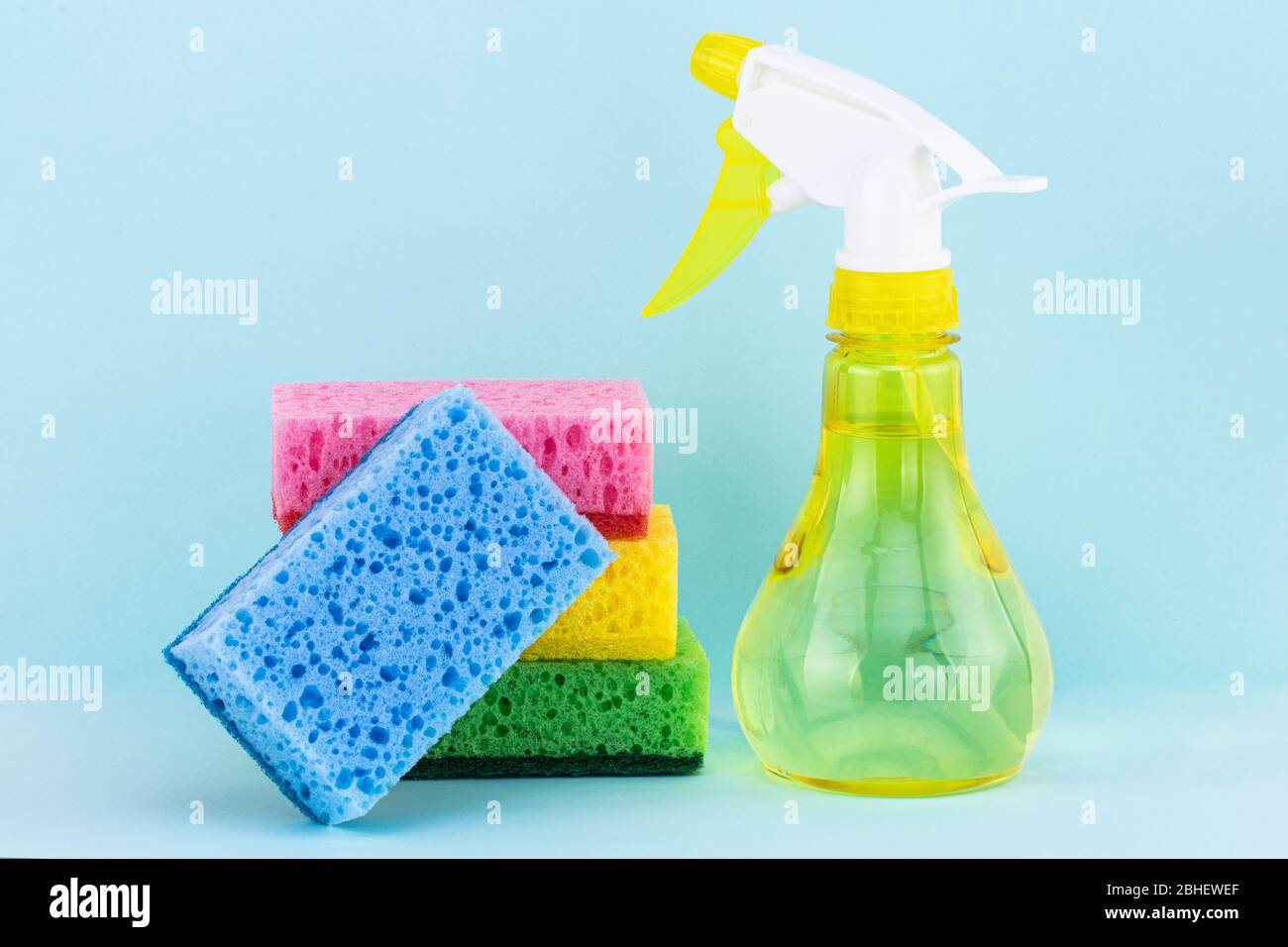éponges pour le lavage de vaisselle et vaporiser du détergent sur un fond bleu. Concept de nettoyage. Banque D'Images