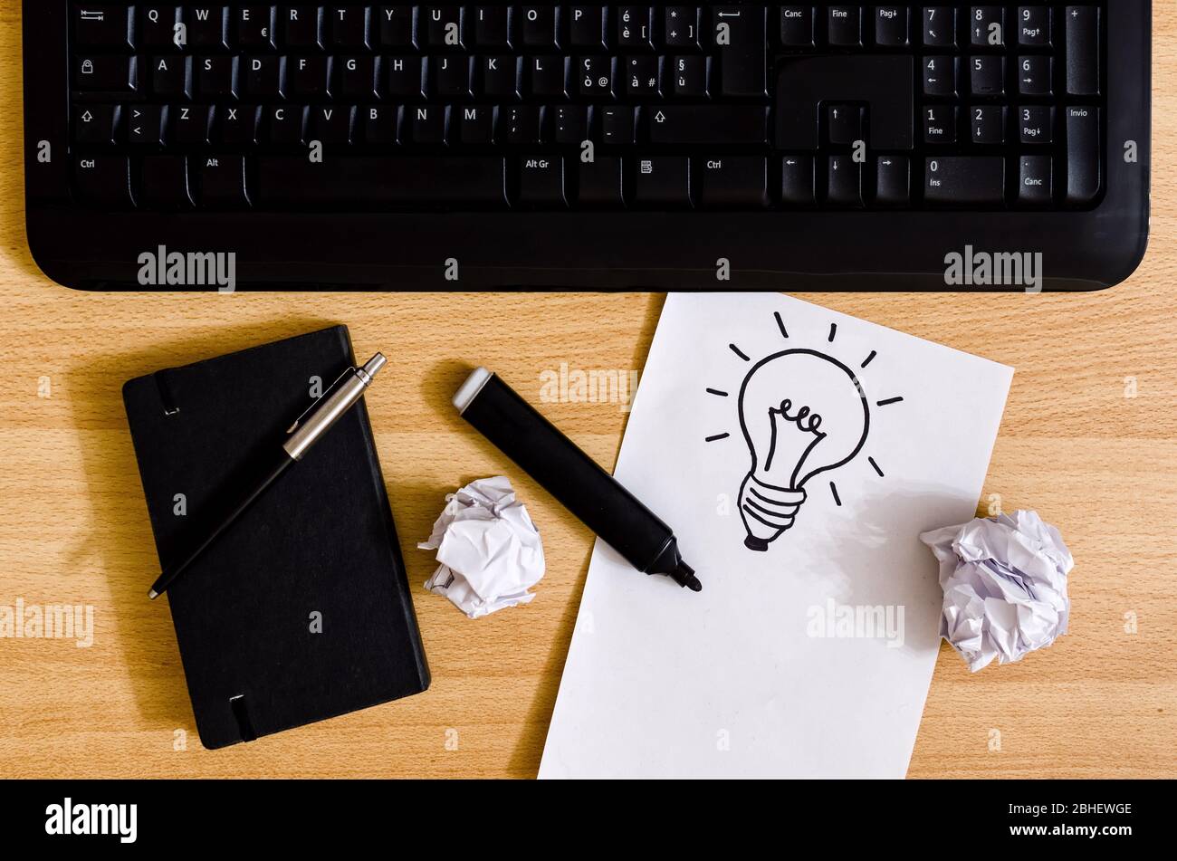 clavier d'ordinateur sur un bureau avec agenda, marqueur, feuilles froissés  et feuille blanche avec un dessin d'ampoule Photo Stock - Alamy