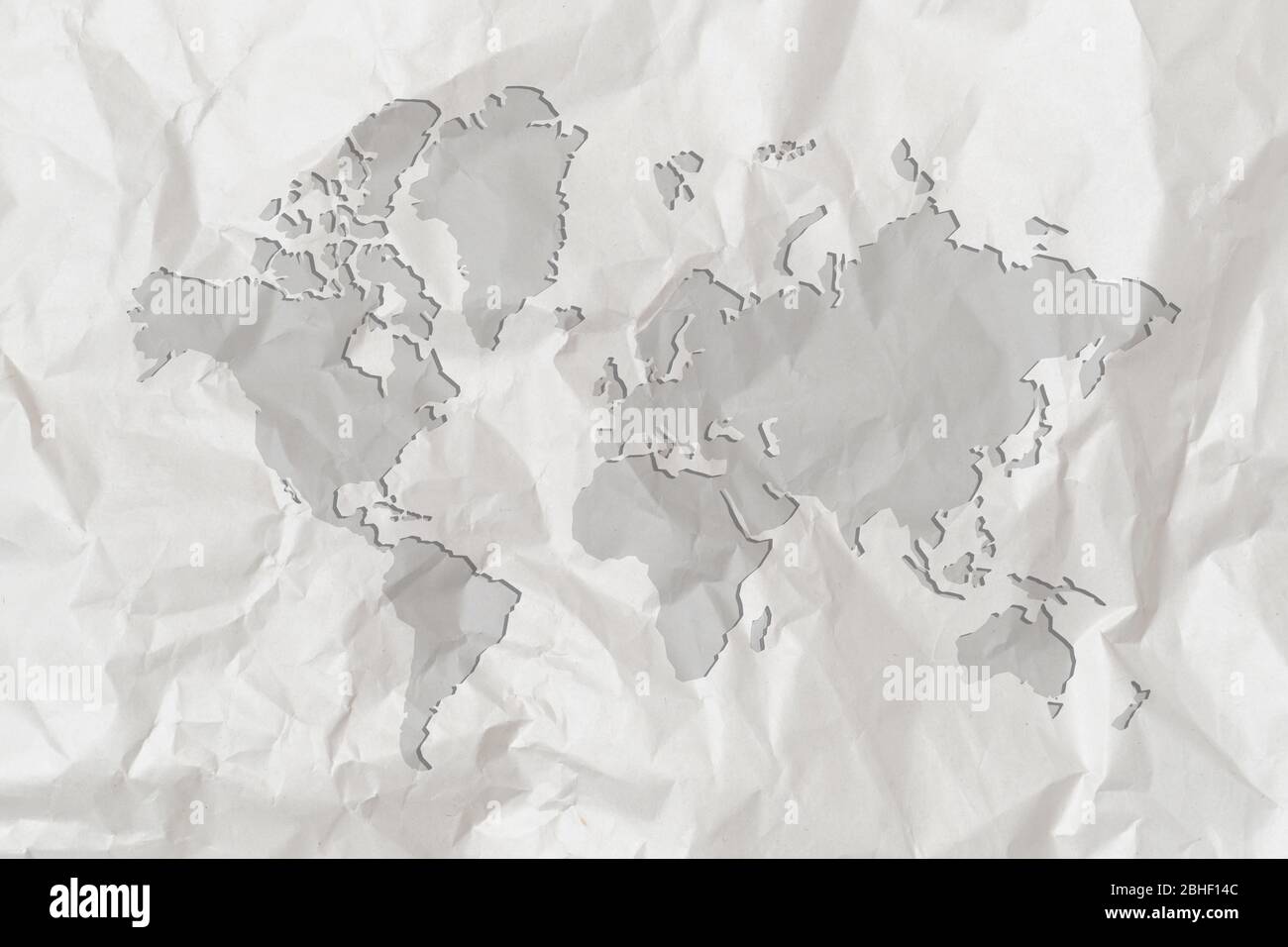 Une carte du monde est représentée sur un livre blanc froissé. Gros plan. Banque D'Images