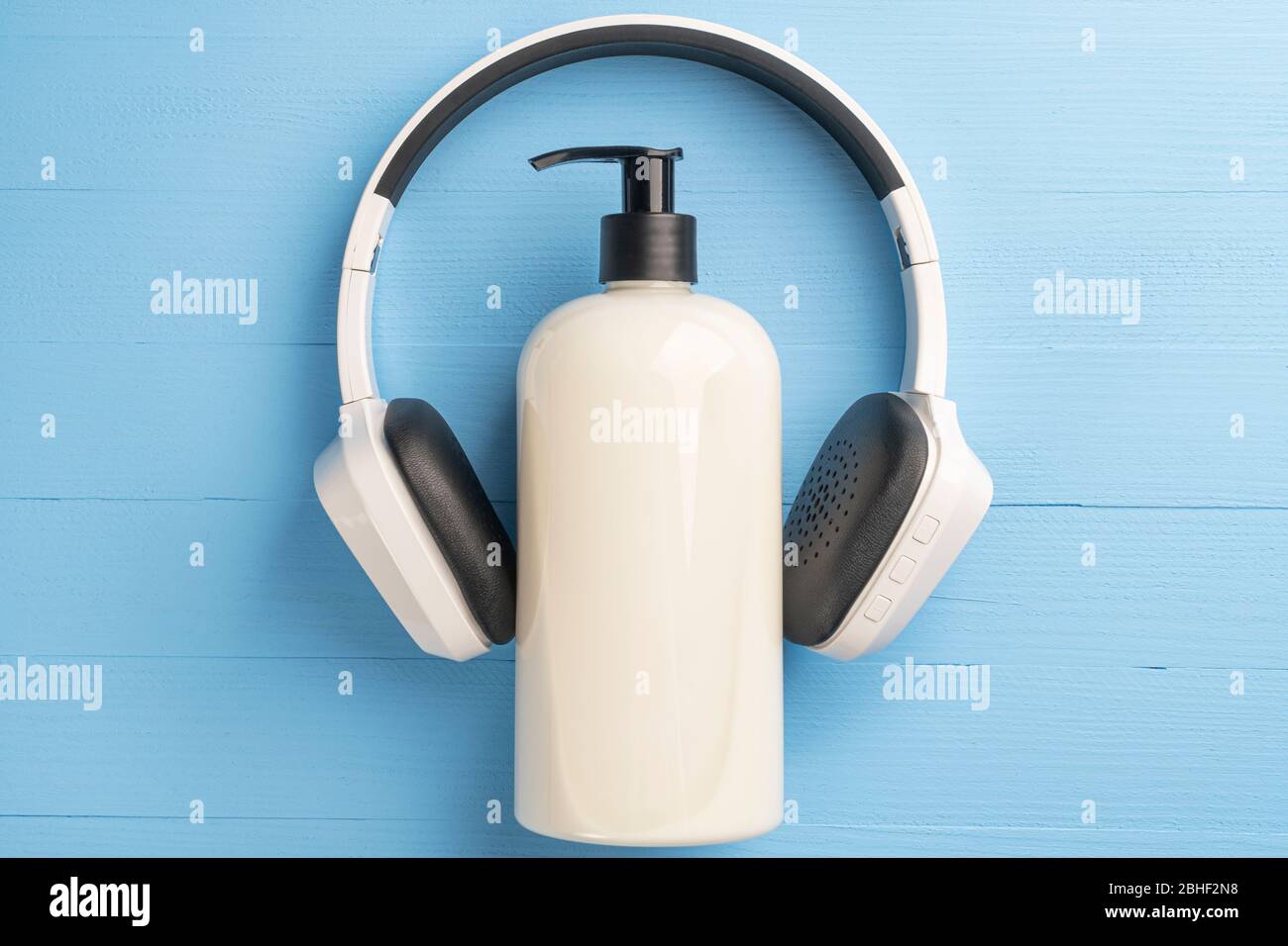 Conteneur en plastique beige avec distributeur et casque sans fil noir  blanc sur fond bleu clair. Le concept de quar de coronavirus Photo Stock -  Alamy