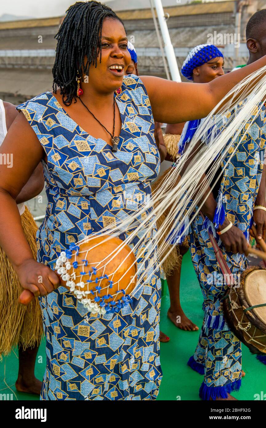 Performance de la troupe nationale de danse de Sierra Leone à bord de l'expédition MS dans le port de Freetown avec une femme jouant des instruments Shekere gourd Banque D'Images