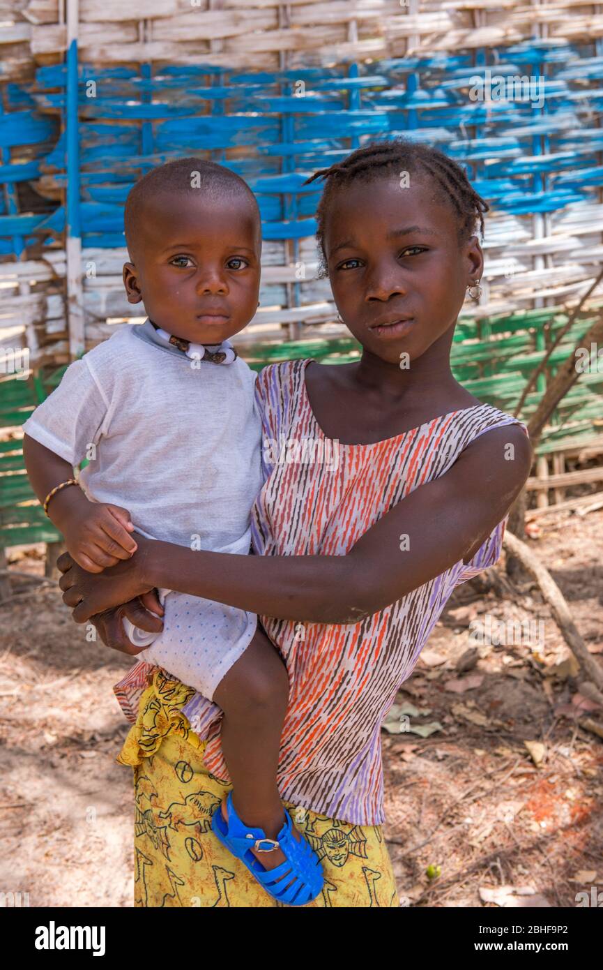 Portrait d'une fille portant un frère plus jeune à la forêt de Makasutu Cutlure en Gambie. Banque D'Images