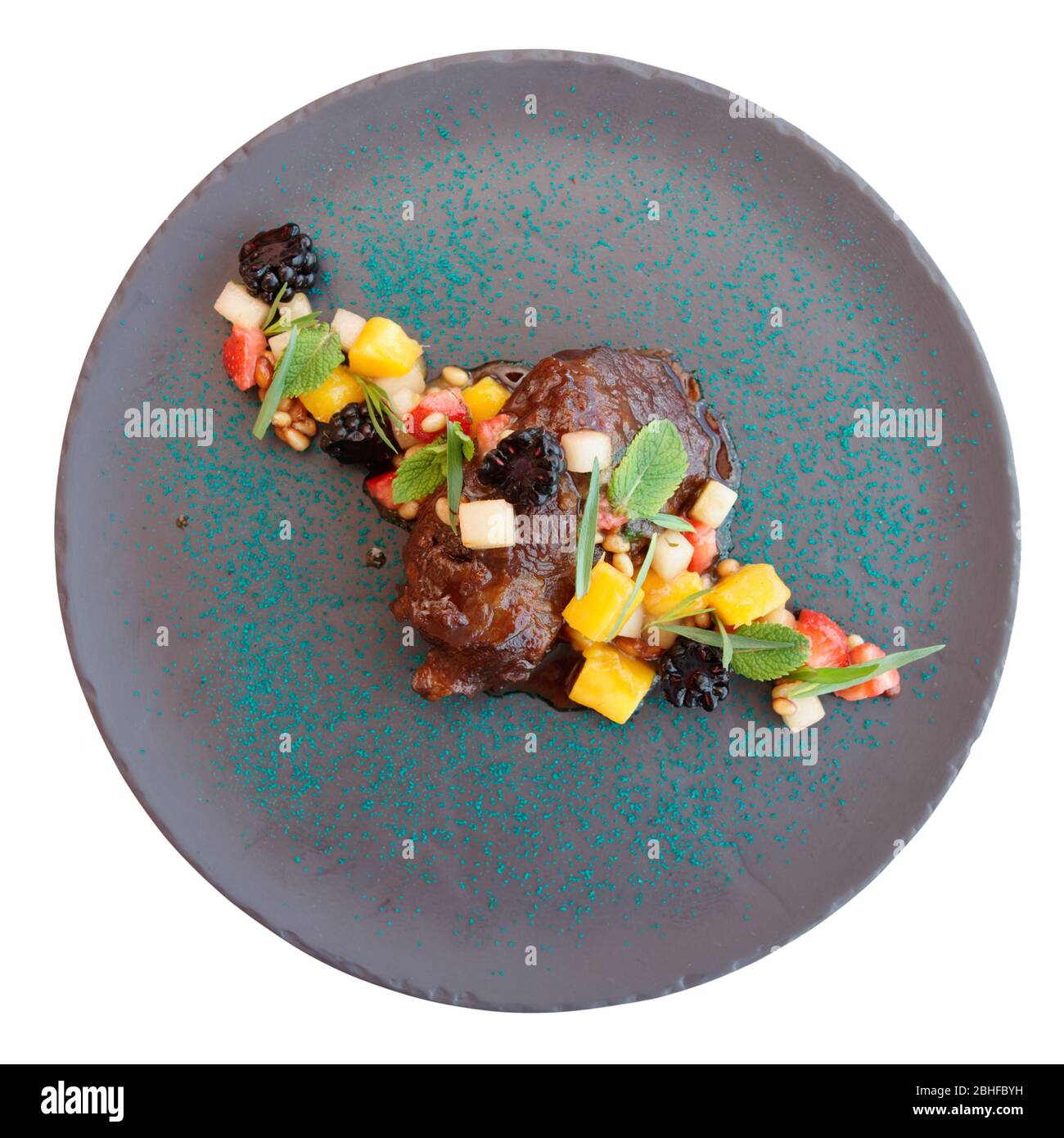 Cheek de veau cuit lentement avec fruits, herbes et baies tirés de dessus, isolé sur fond blanc Banque D'Images