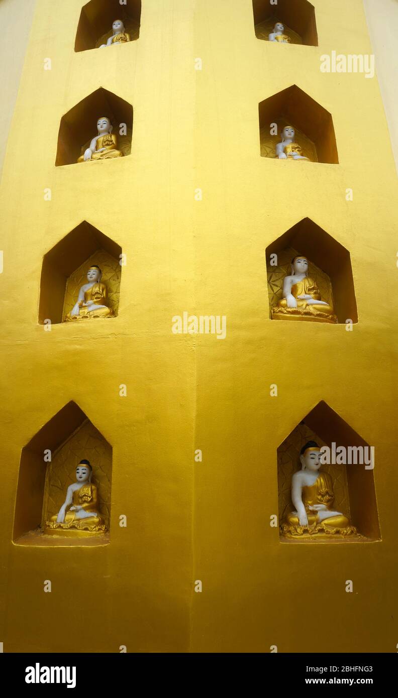 Statues religieuses dans des niches dans un mur à l'or dans un temple au sommet du lieu de pèlerinage du Mont Popa, dans le centre du Myanmar Banque D'Images