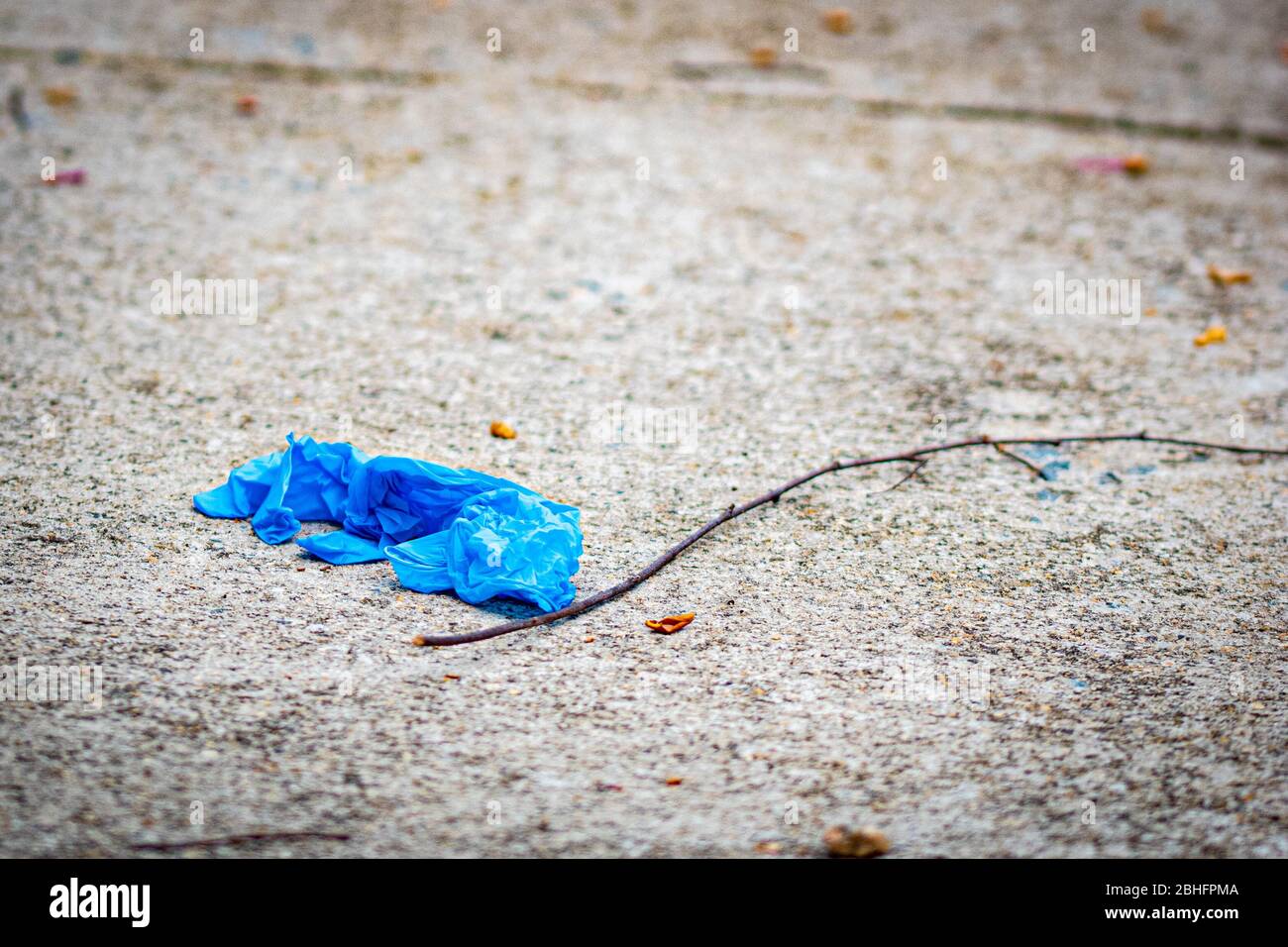 Gants de protection bleus sur le trottoir pendant l'éclosion du virus corona Banque D'Images