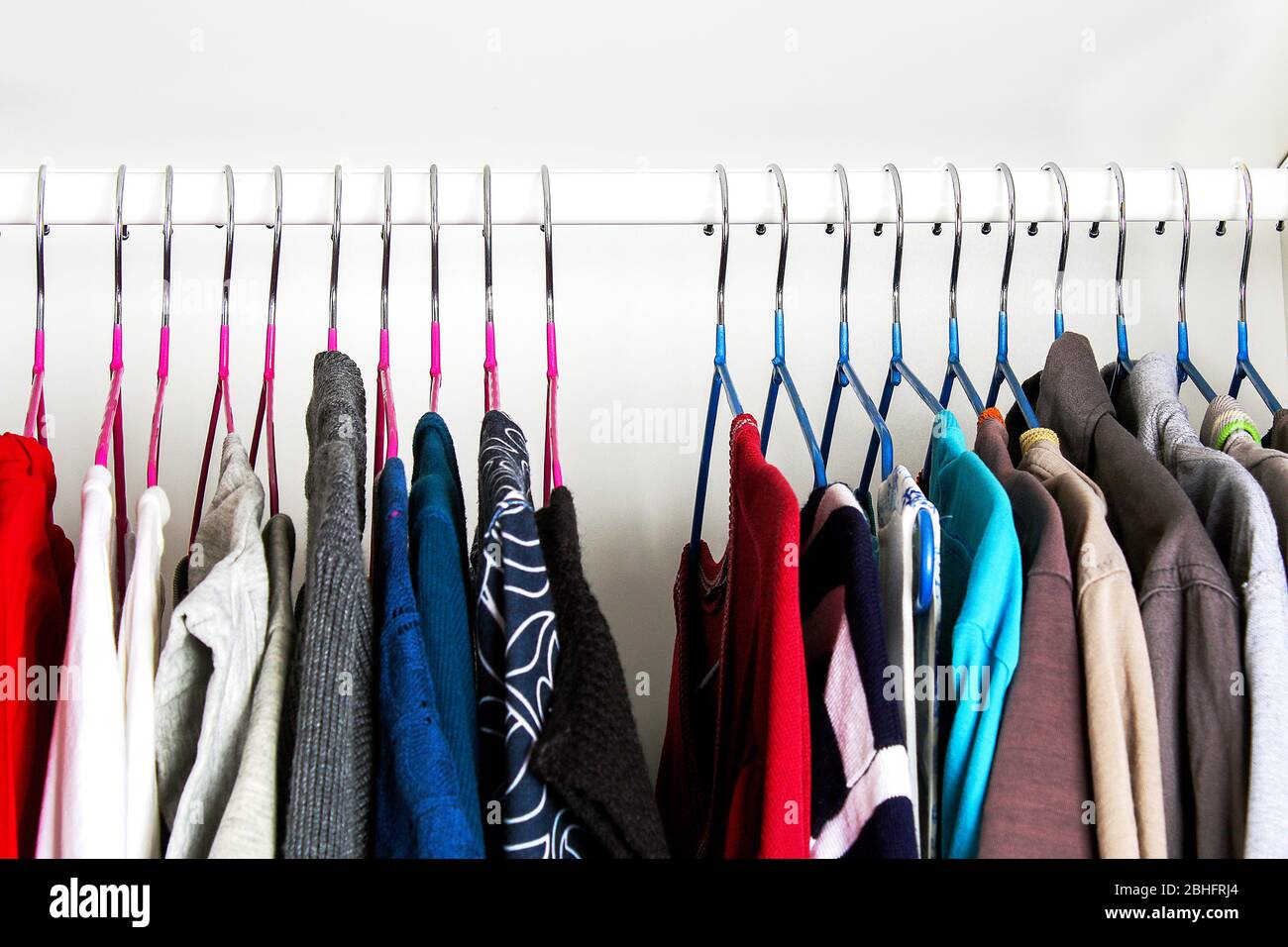 Vêtements pour hommes et pour femmes sur cintres en silicone dans le placard de la penderie. Les mêmes épaules. Organisation du stockage. Ordre et propreté. Quarantaine, se Banque D'Images